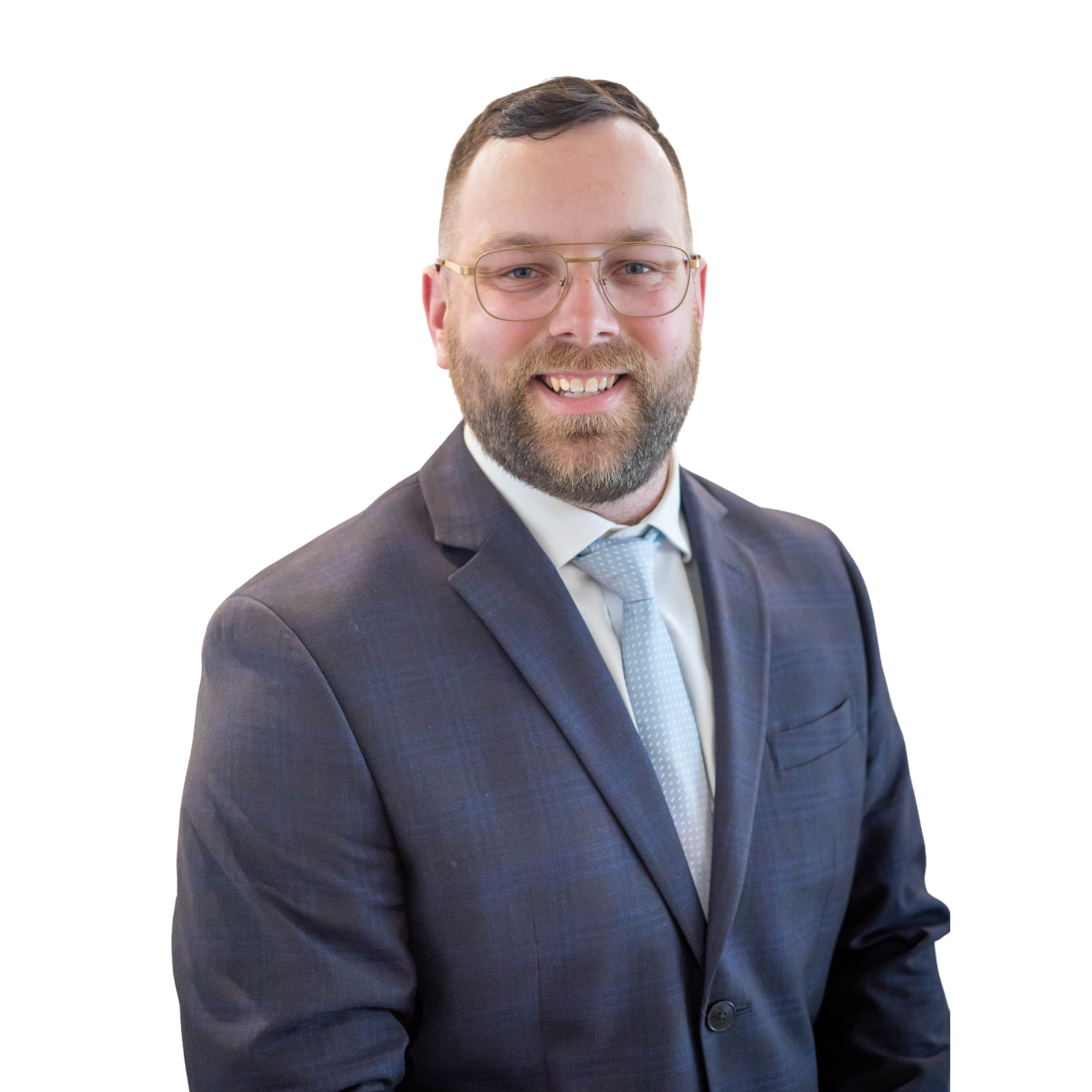 Headshot of a man with short dark hair, glasses, and a beard, wearing a suit and tie, smiling against a white background.