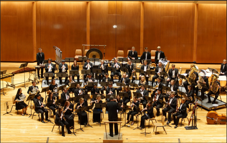 A wind orchestra. The percussion are curved around the back of the ensemble from stage left to stage right.