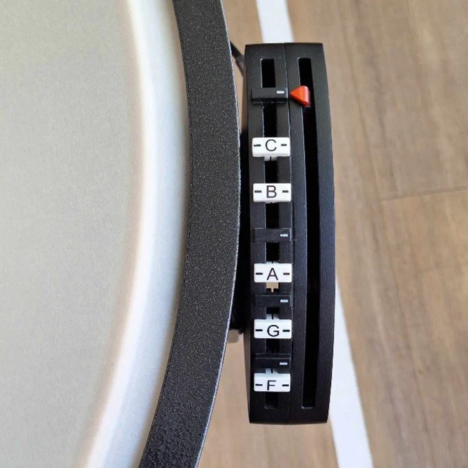 Close-up of a Yamaha timpano tuning gauge, featuring additional indices between the letters to help identify accidentals.