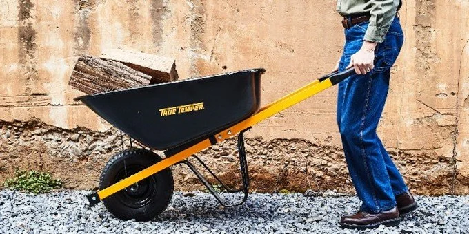 Picture of someone lifting a wheelbarrow, emphasising how best to lift timpani.