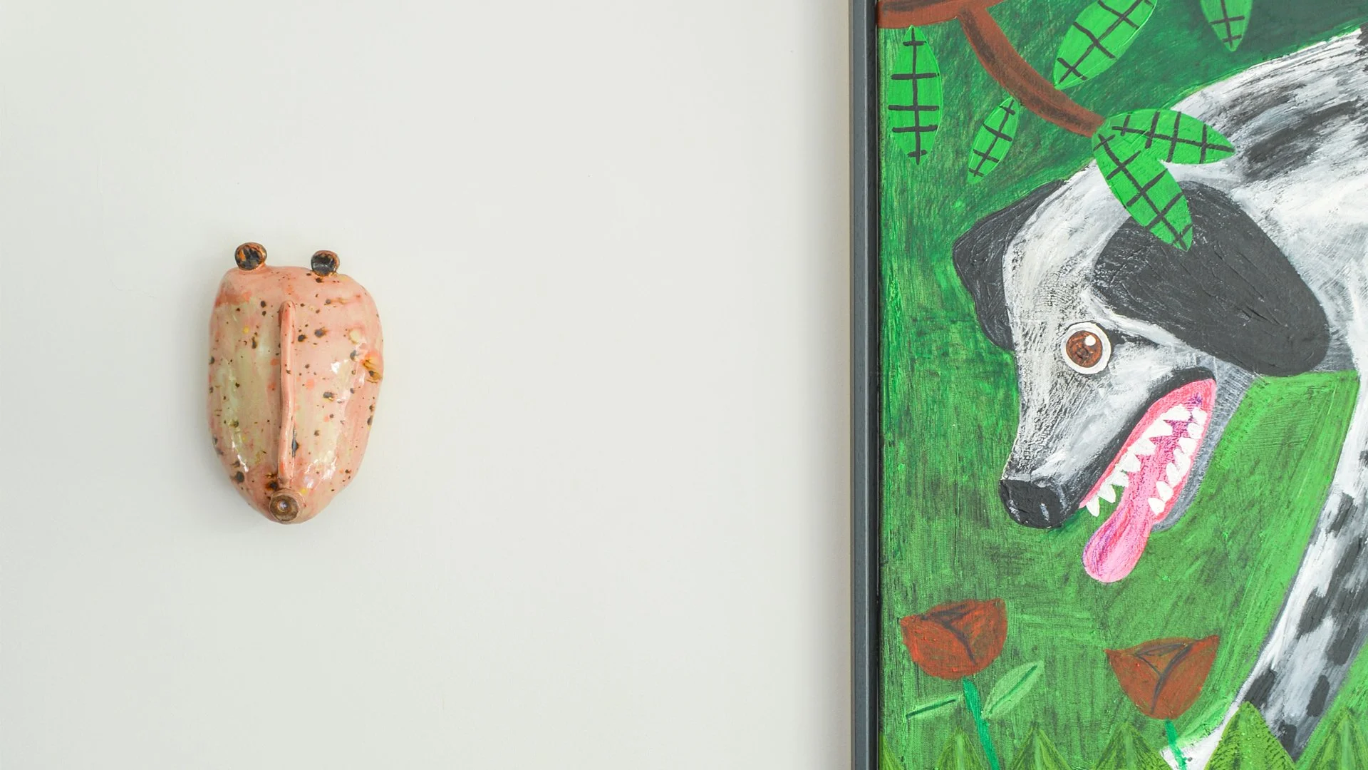 Hedendaagse, figuratieve kunstwerken van geïnstalleerd in een privé woning van een kunstverzamelaar. één keramisch werk, gemaak van geglazuurde keramiek en een figuratief schilderij van een hond, ingekaderd volgens het kleurenpalet van het interieur.