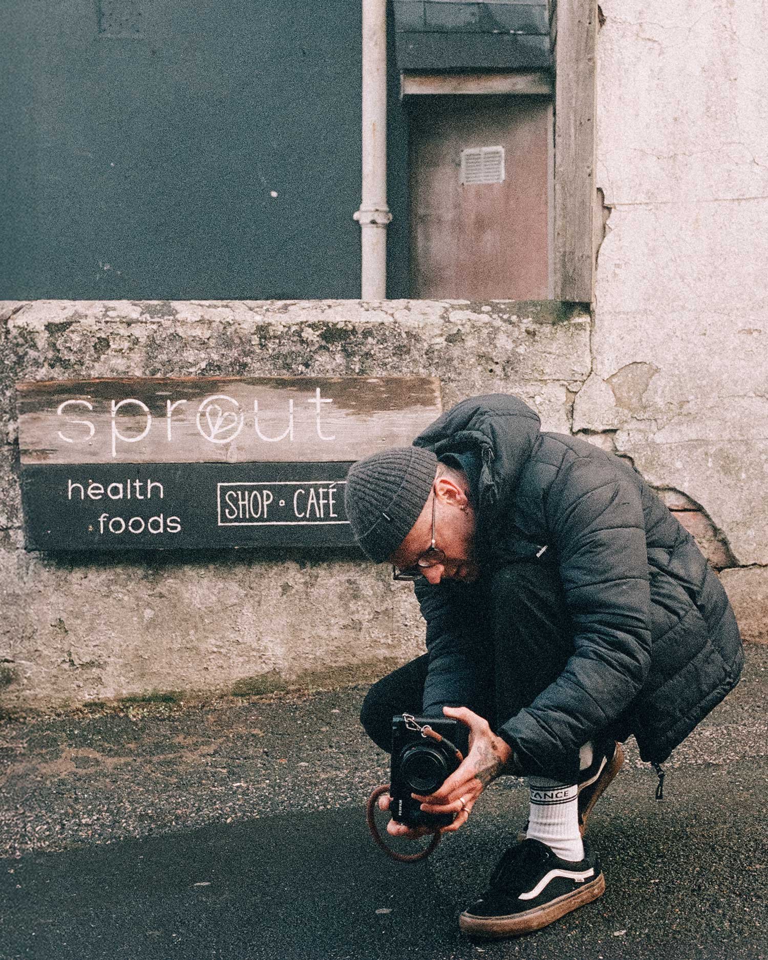 Editorial portrait of photographer shooting 35mm film in urban setting, photographed by Karl Mackie
