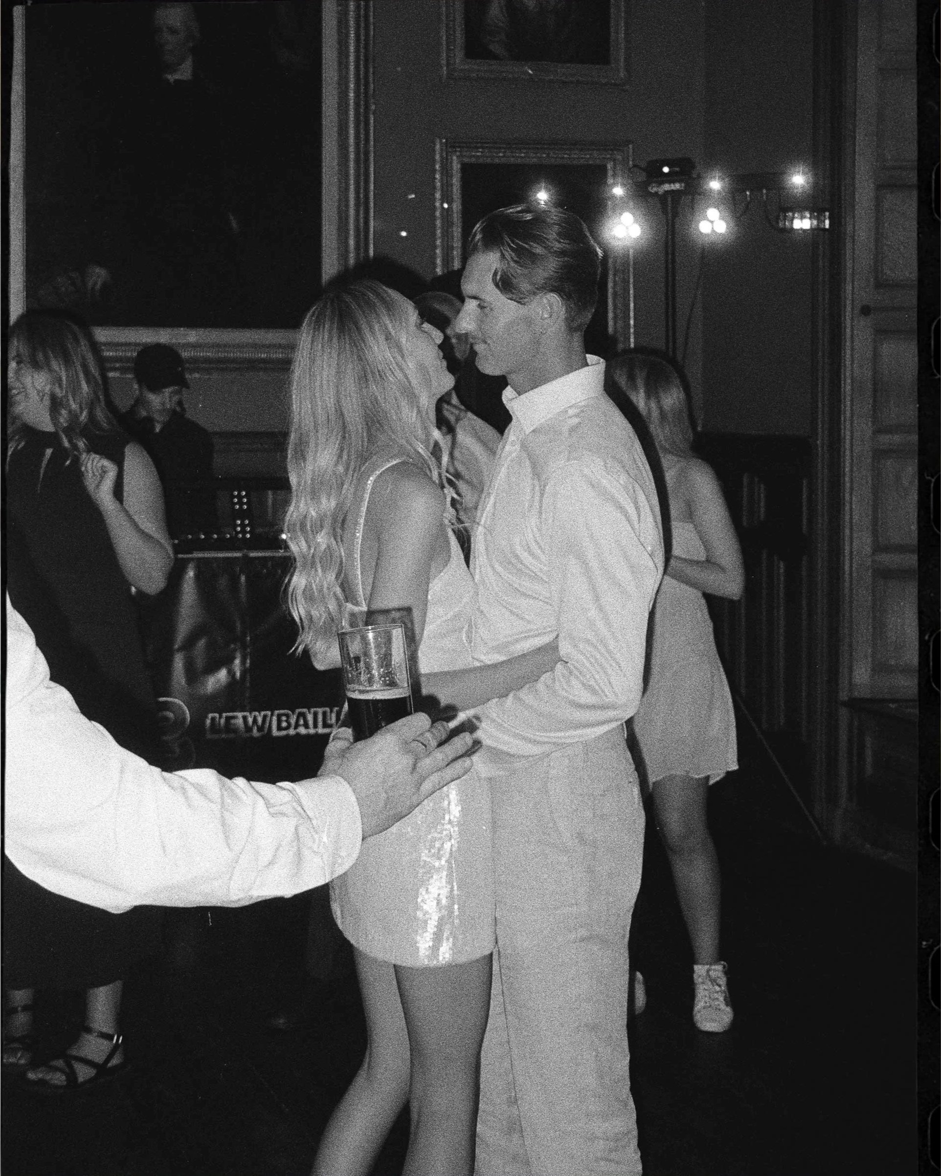 Black and white editorial film photograph of bride and groom dancing at a reception, captured on analogue by Karl Mackie