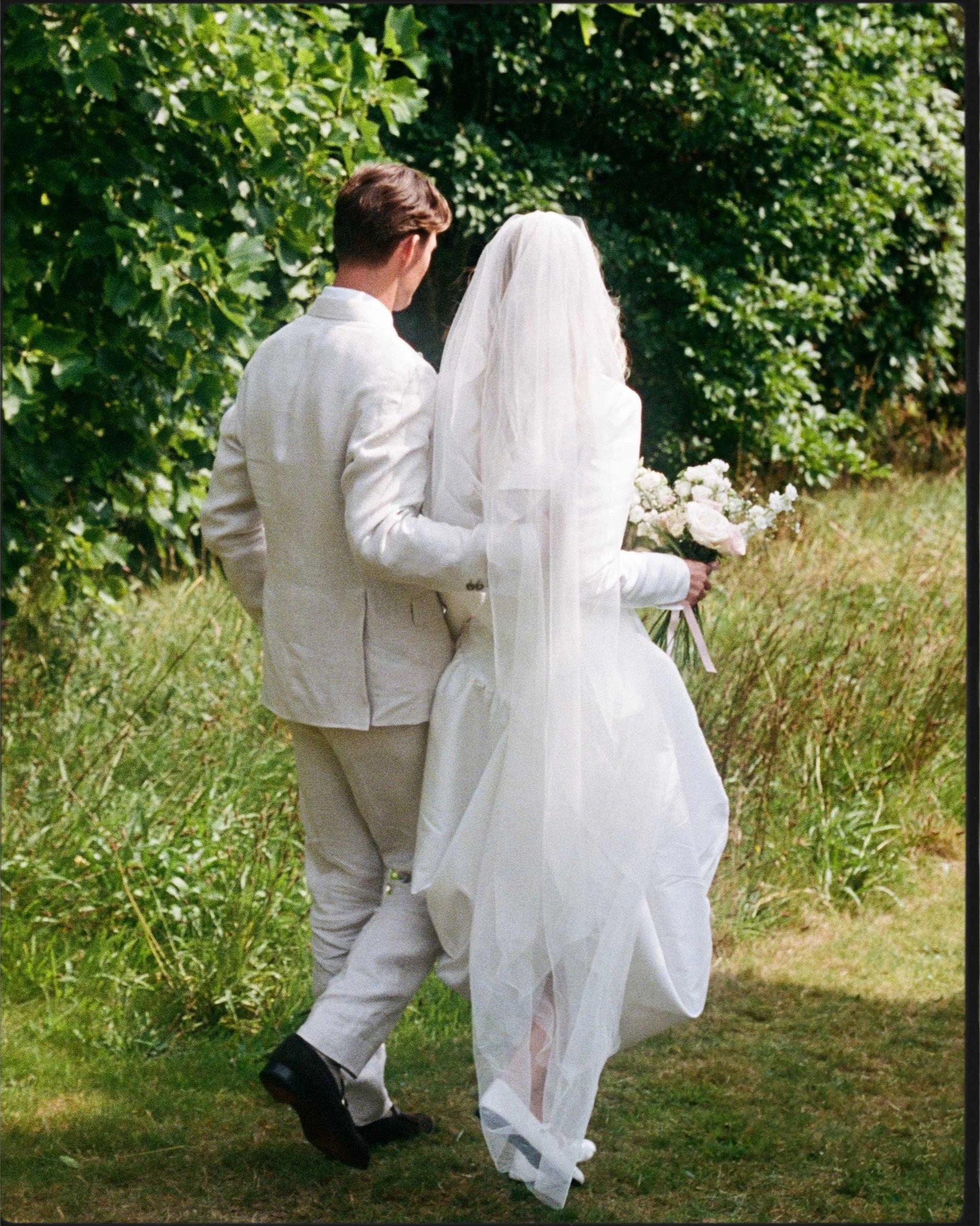 Documentary wedding photography, couple walking through garden at country house venue, captured on 35mm film