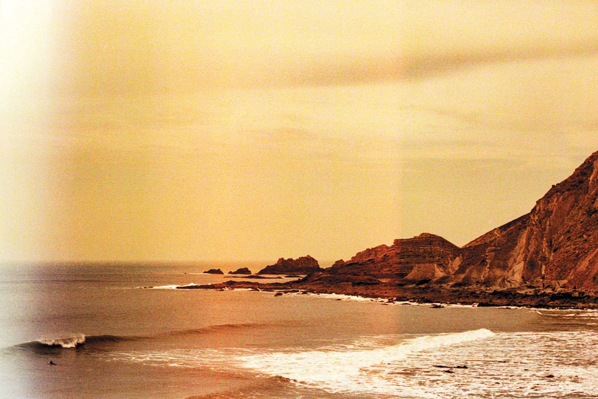 35mm film photograph of the Hartland coastline in North Devon by Karl Mackie featuring warm ocean light and rolling surf