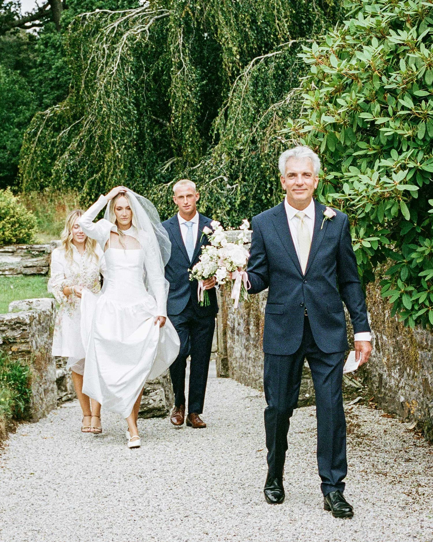 Bride and groom walking through the gardens at Boconnoc during their Cornwall wedding
