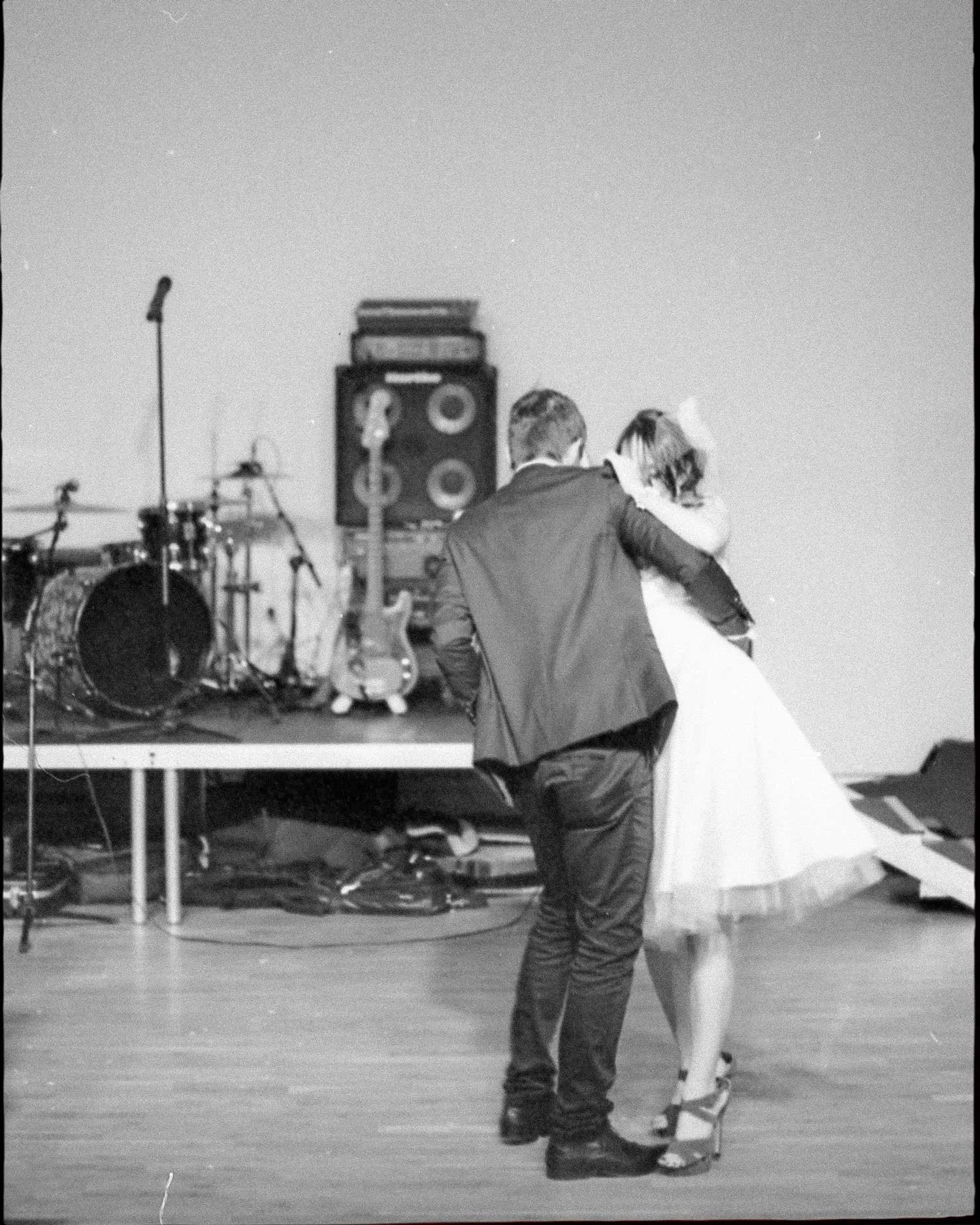 Black and white editorial film photograph of bride and groom dancing at reception, captured on analogue by Karl Mackie