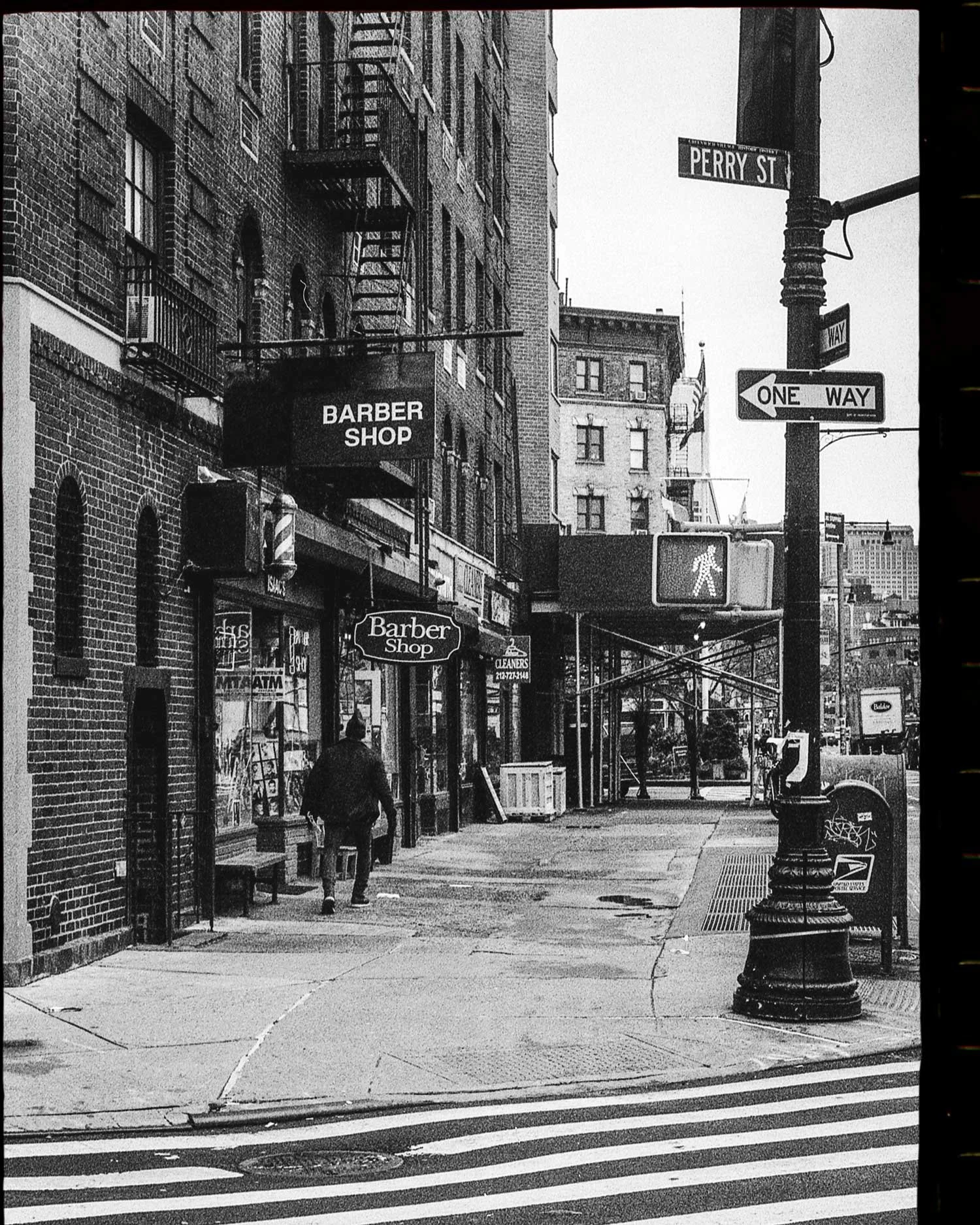 Black and white film photograph of New York street scene on Perry Street, editorial urban photography by Karl Mackie