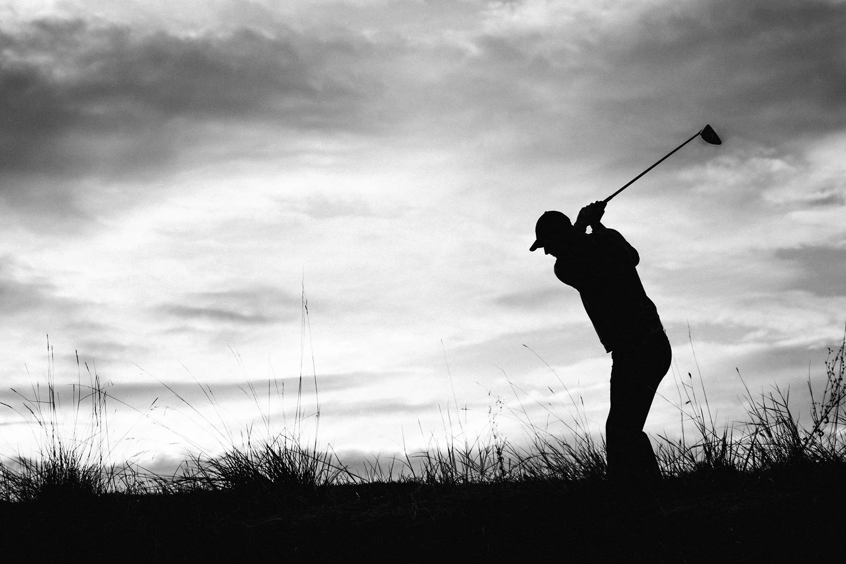 Professional golfer Nicolas Colsaerts silhouetted during his swing on a golf course in Colorado, photographed by Karl Mackie.