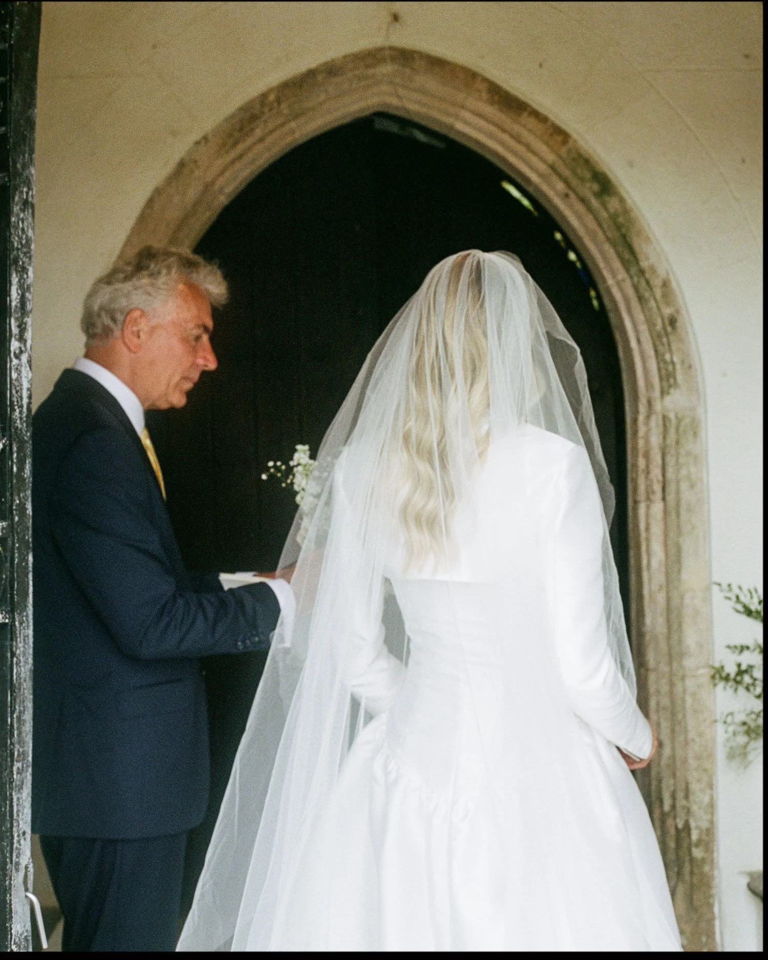 35mm film wedding photograph of bride entering ceremony, documentary storytelling approach