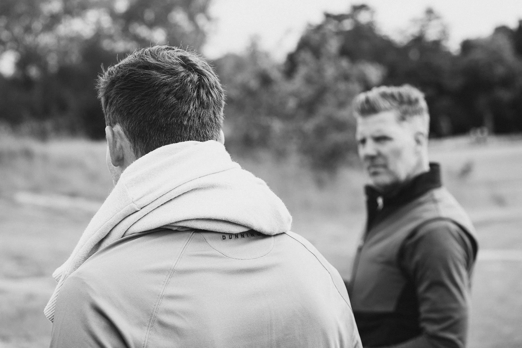 Dunning golfers in conversation on the course at The K Club in Ireland, photographed in black and white.