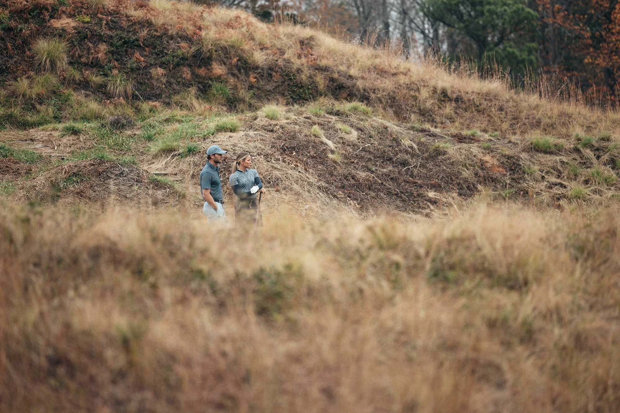 Two golfers walking through the rugged landscape at Tobacco Road Golf Club, North Carolina, photographed by Karl Mackie.