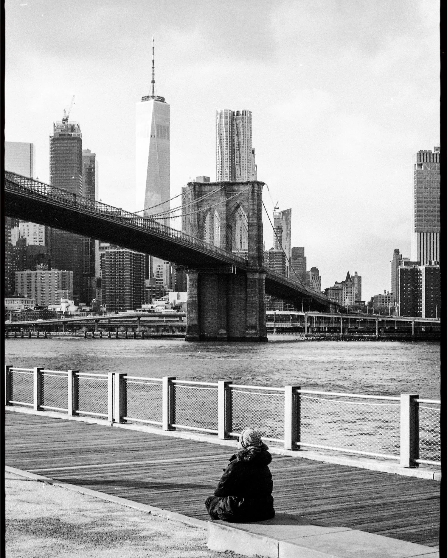 Editorial black and white film photograph of Brooklyn Bridge and Lower Manhattan skyline by UK-based analogue photographer Karl Mackie