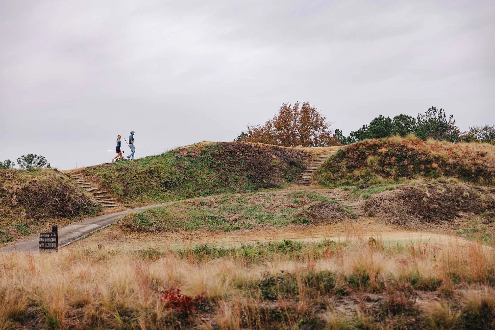 Two golfers walking through the rolling landscape of Tobacco Road Golf Club in North Carolina