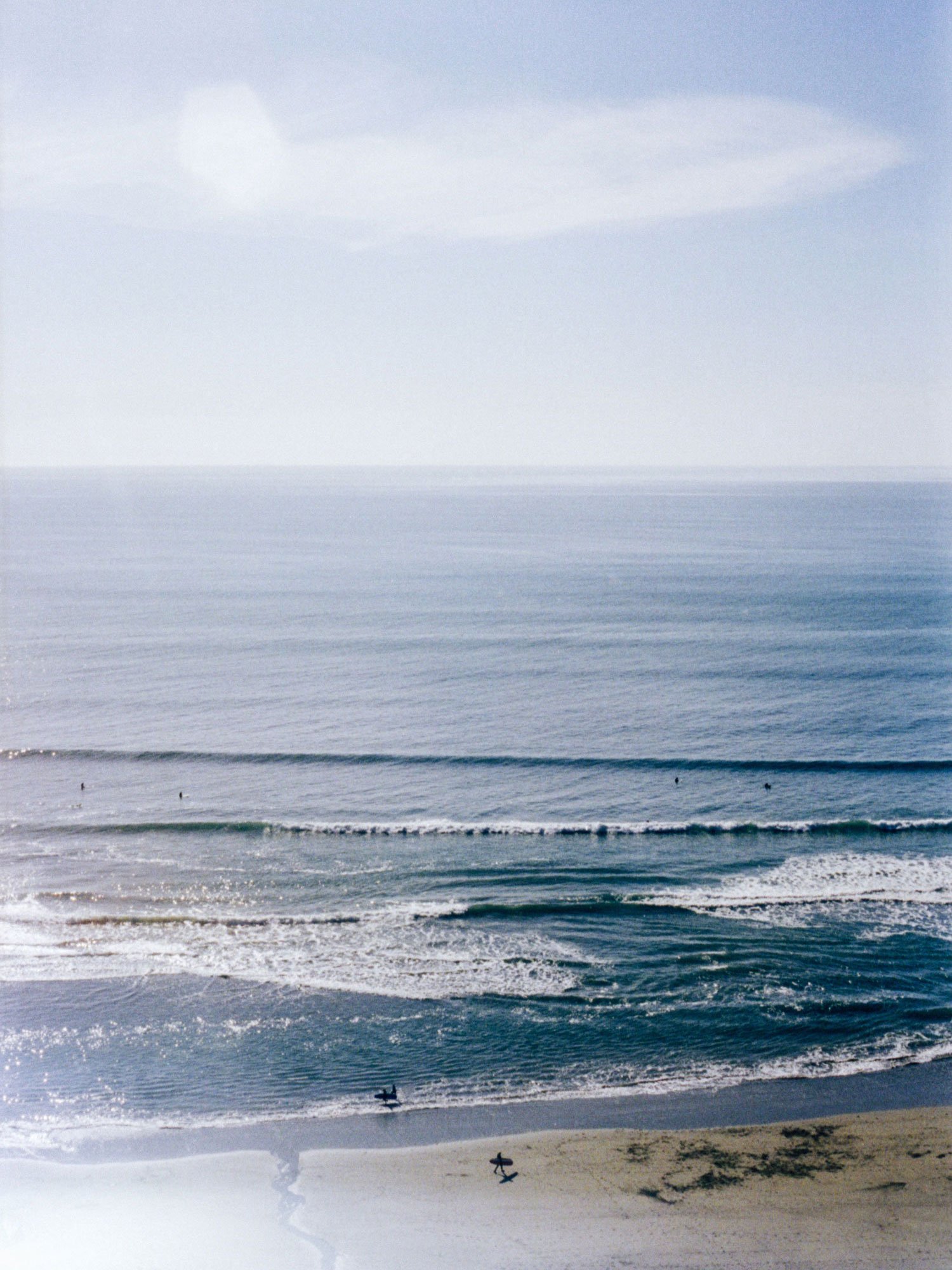 35mm film photograph of Whitsands Bay in Cornwall by Karl Mackie featuring soft ocean light and peeling waves viewed from the cliffs