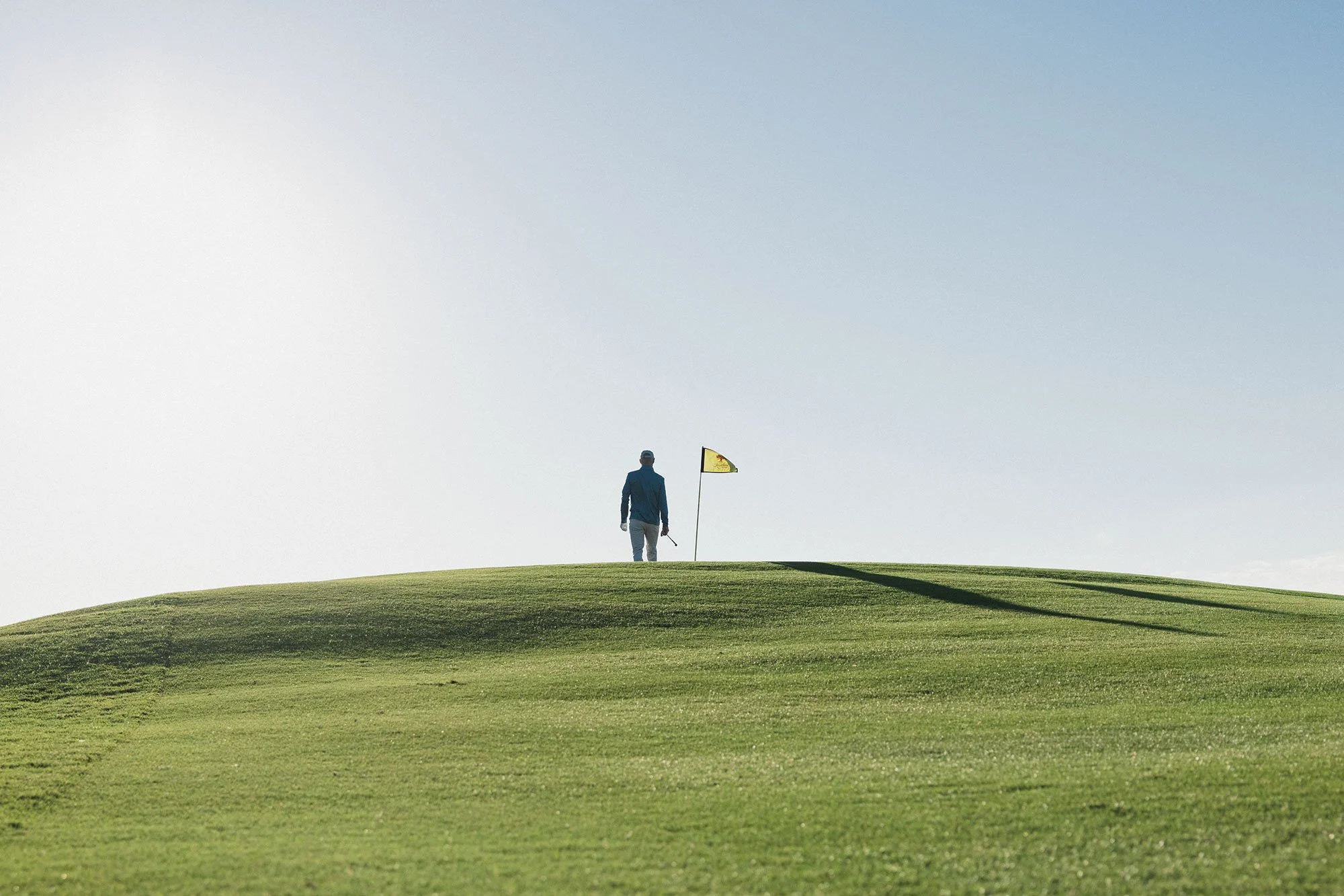 Lone golfer silhouetted on the crest of a green at Kiawah Island