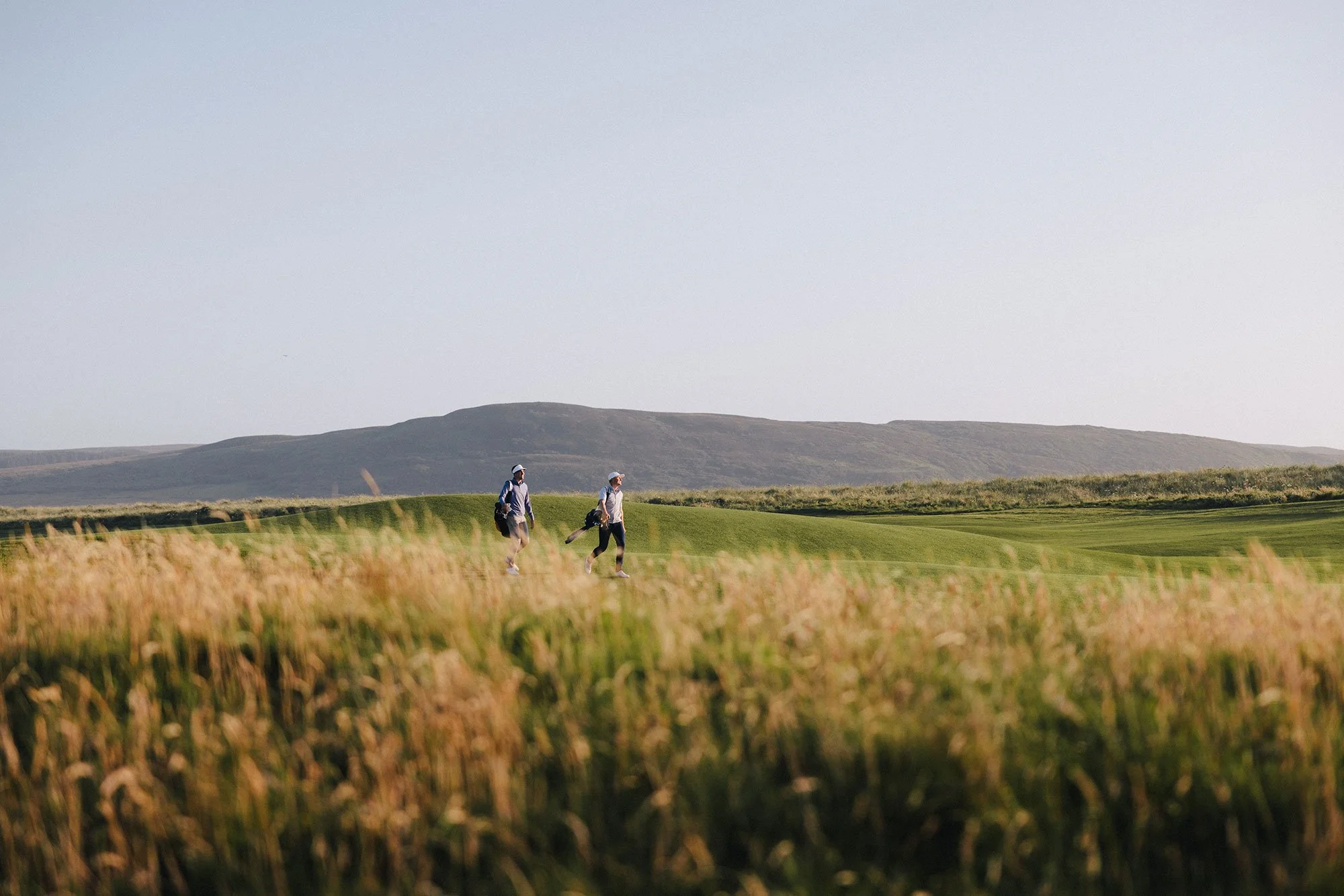 Golfers walking through The Machrie golf course in Scotland, photographed for Holderness & Bourne by Karl Mackie.