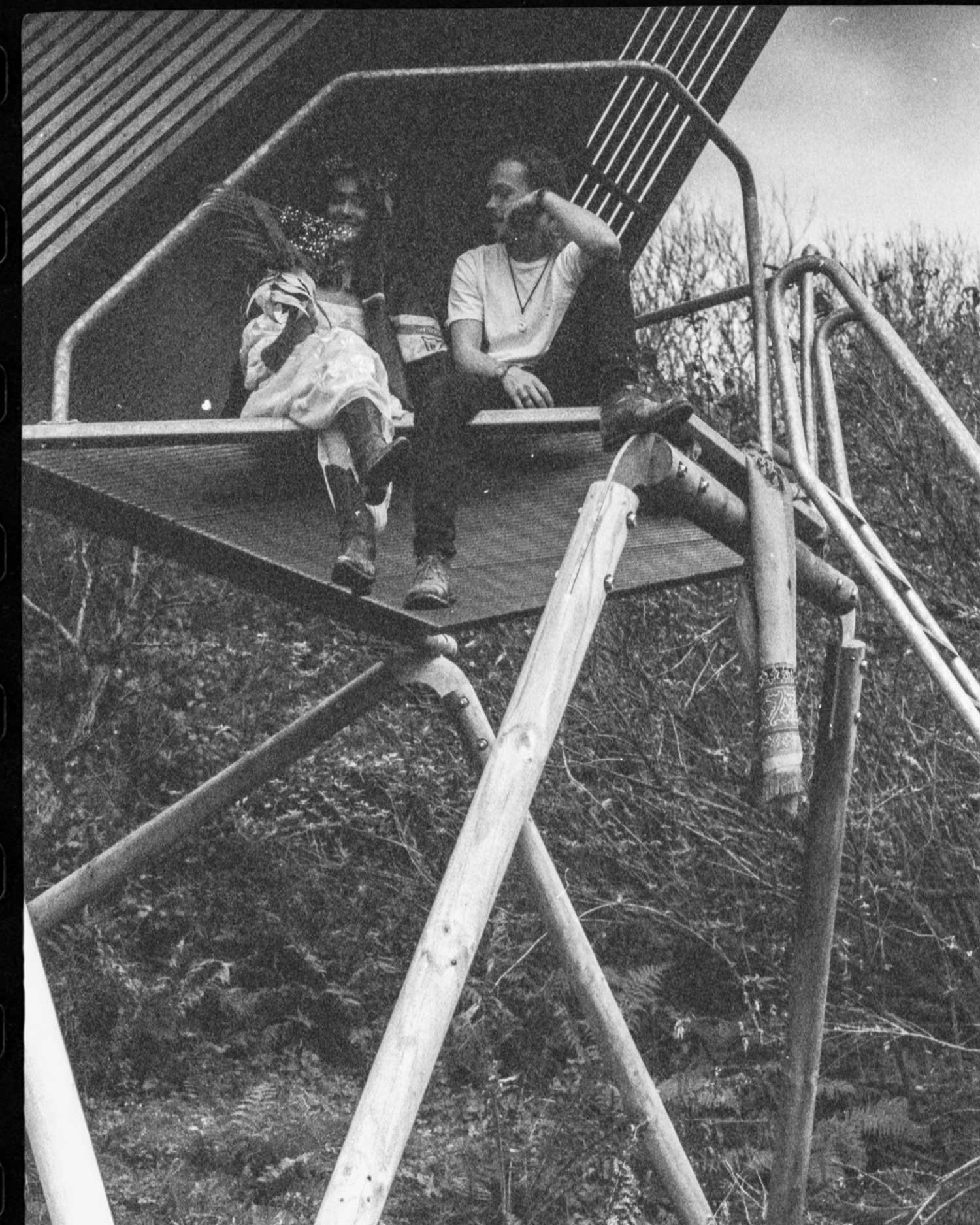 Black and white editorial film portrait of two people seated on a Kudhva K1, photographed by analogue photographer Karl Mackie