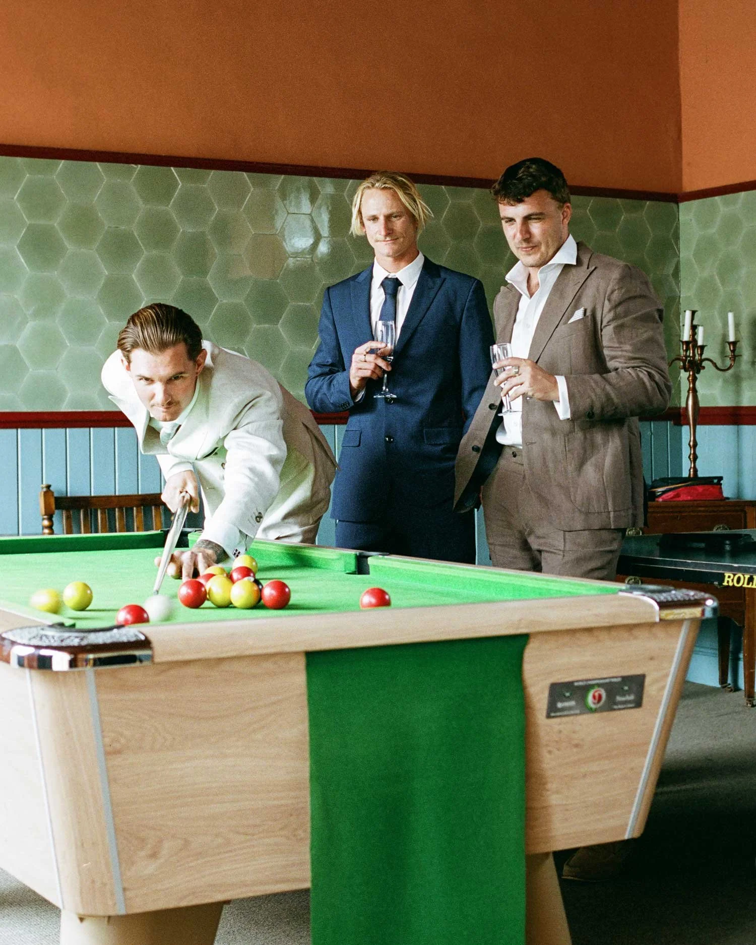 Film documentary wedding photograph of groomsmen playing pool at Boconnoc House, candid wedding moment captured on 35mm