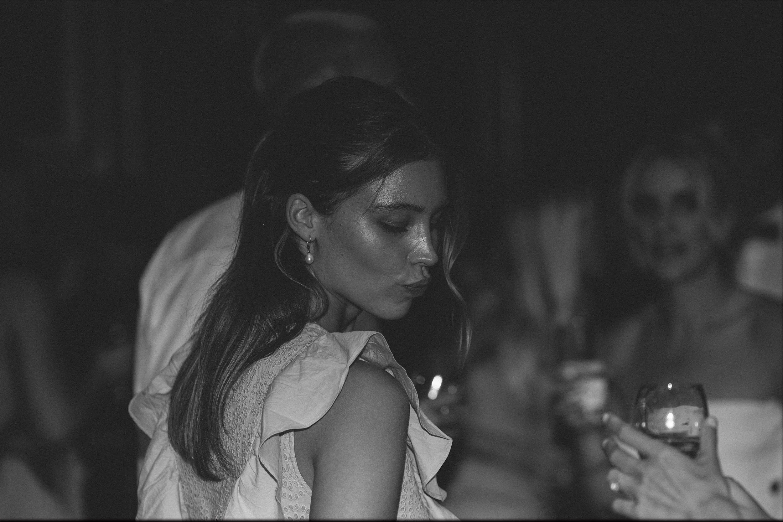 Black and white 35mm film wedding portrait during evening reception, candid documentary moment