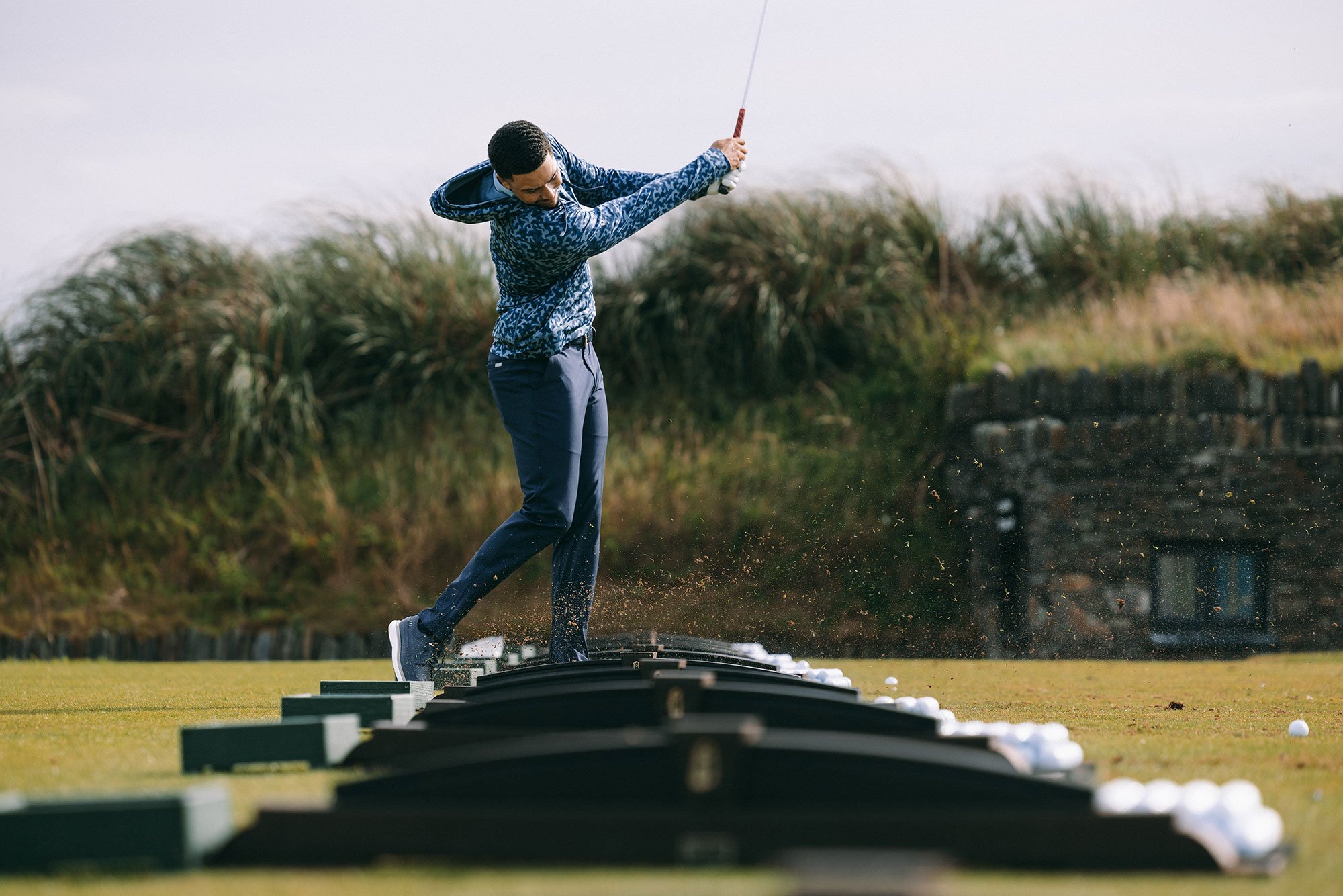 Golfer hitting a shot on the driving range at Old Head Golf Links in Ireland