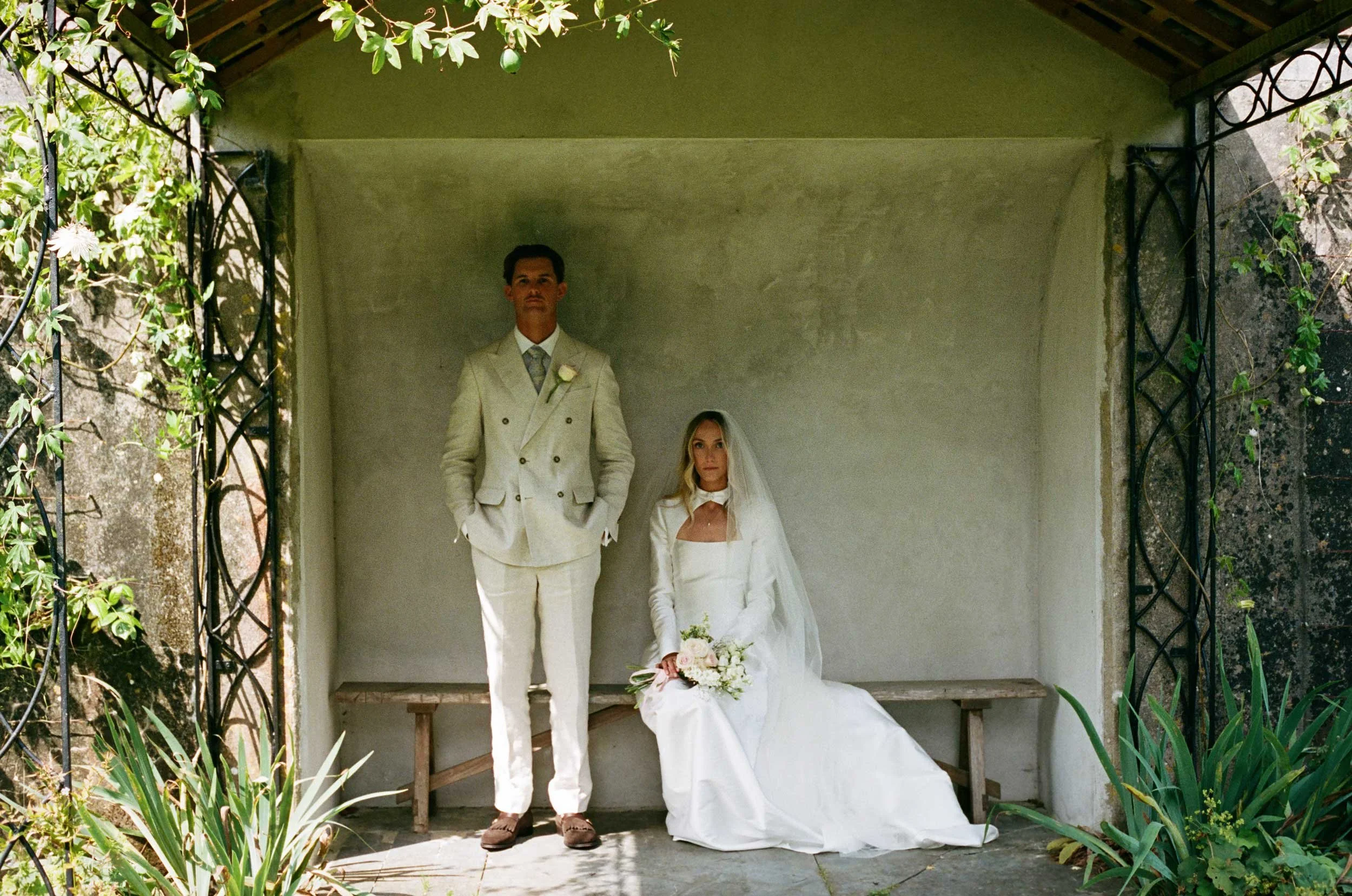 Editorial 35mm film wedding photograph of couple in garden pavilion, relaxed documentary approach