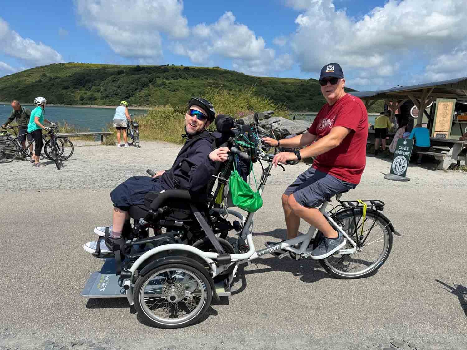 Dad and son enjoying a bike ride on the wheelchair bike on the Camel Trail in the summer