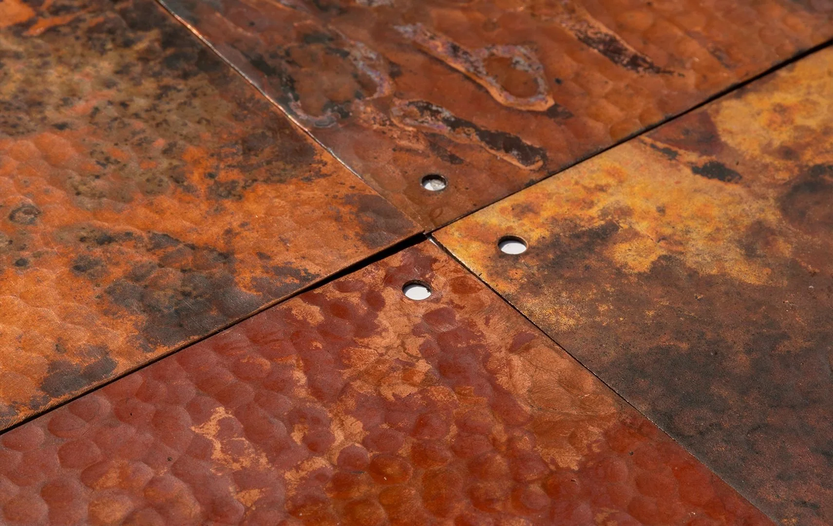 Hand-hammered copper panels with natural patina, AmorettiLAB workshop