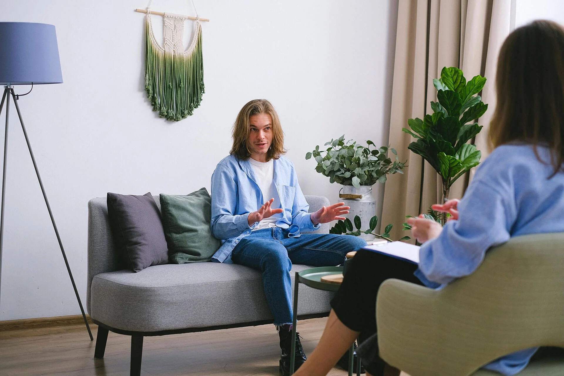 A man sitting on a couch, across from a professional person with a notepad