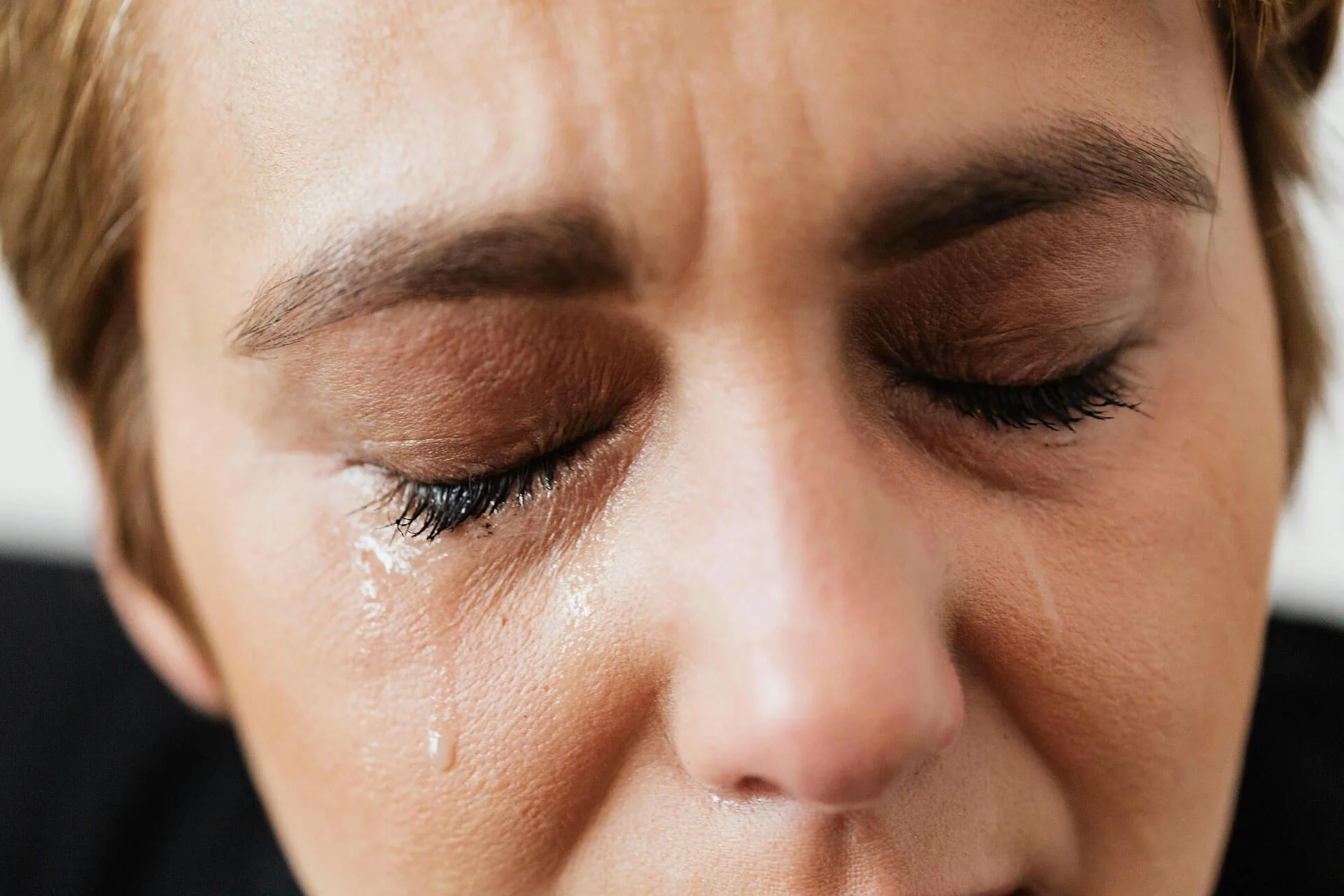 A close up of a person crying a single tear