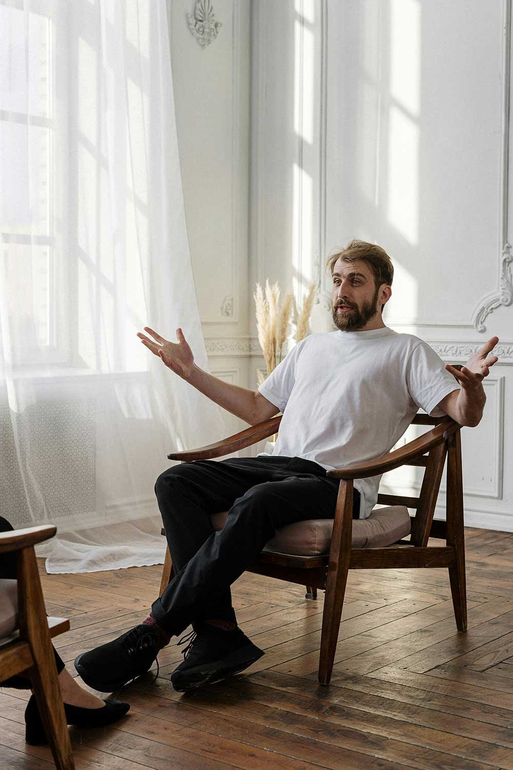 A man sitting in a chair, talking expressively