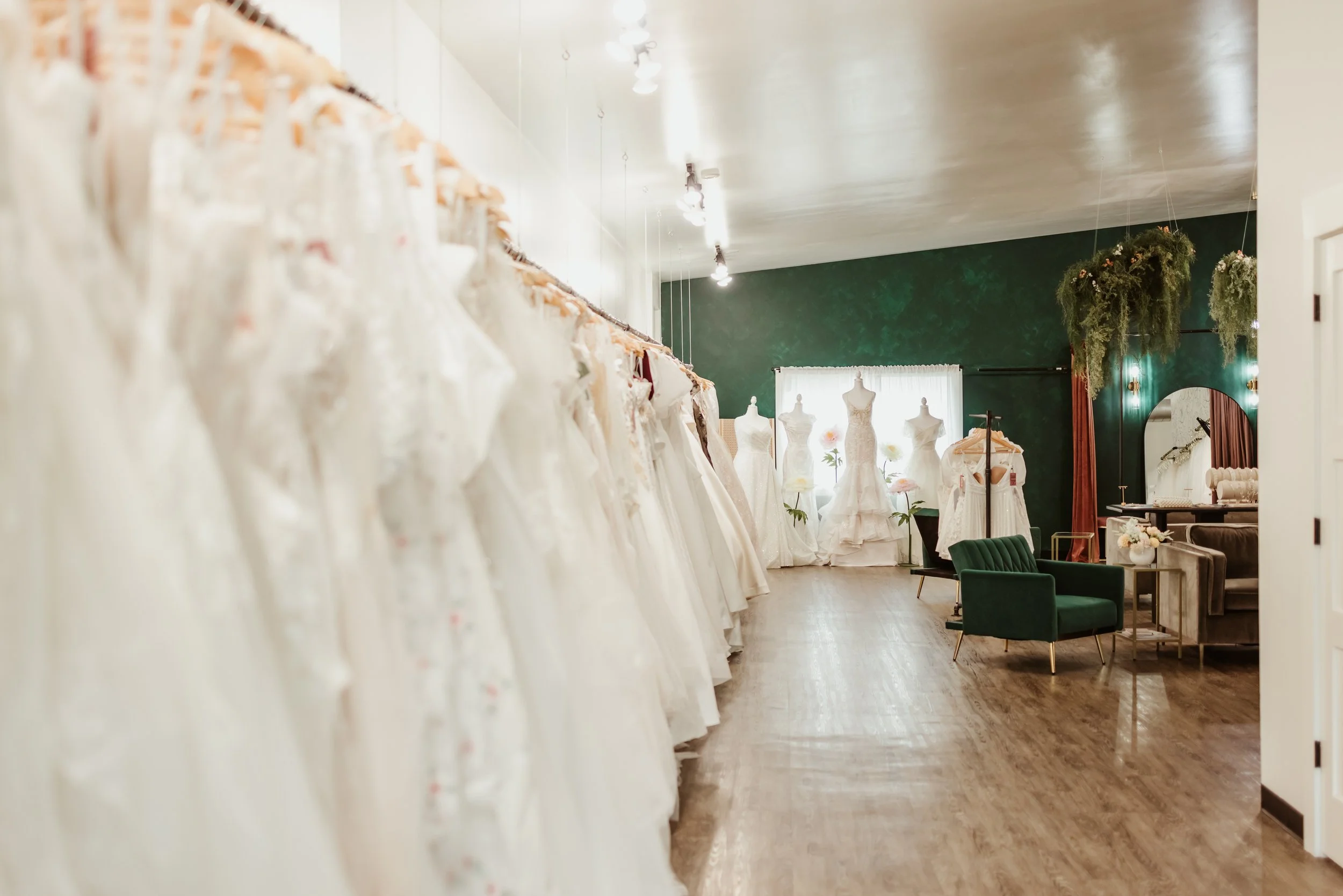 A shot of inside a bridal shop, showcasing the selection of gowns and four mannequins