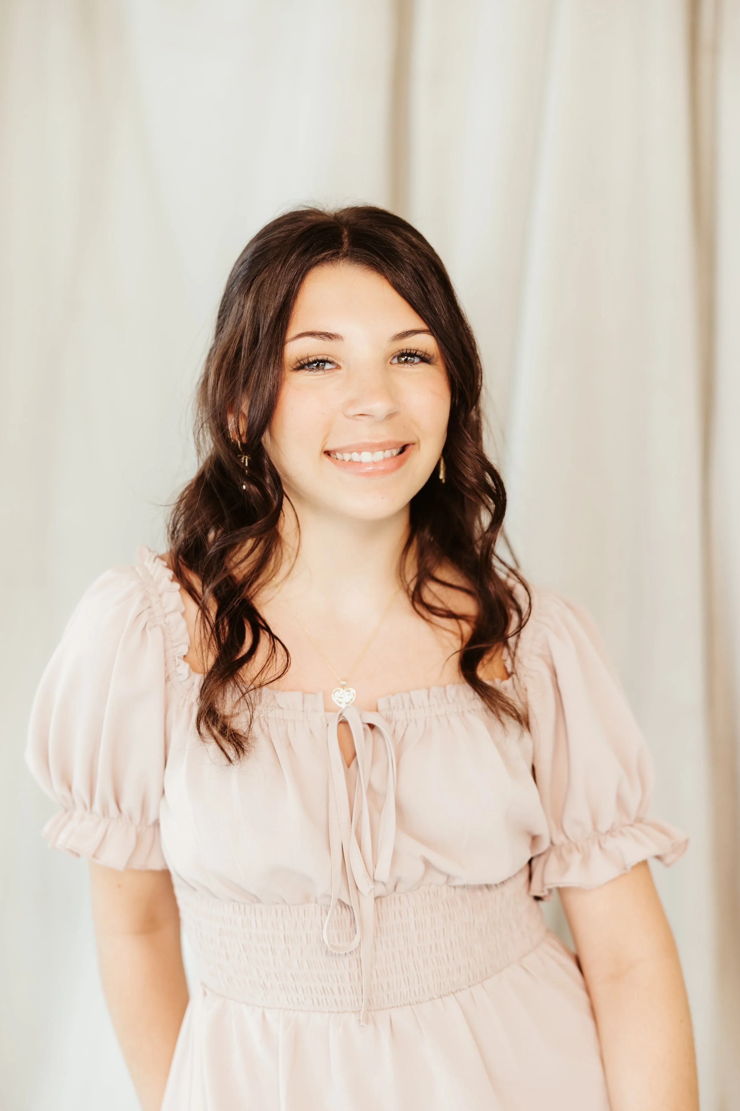 A woman sitting on a stool smiling