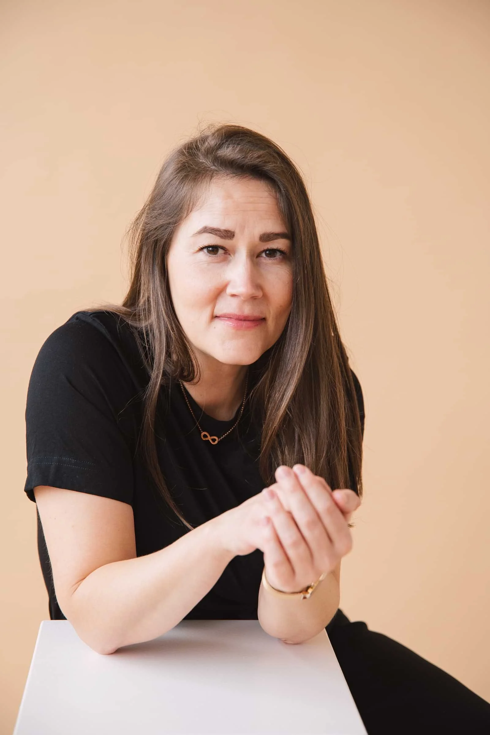 Frau in schwarzem T-Shirt schaut einen offen, leicht lächelnd an