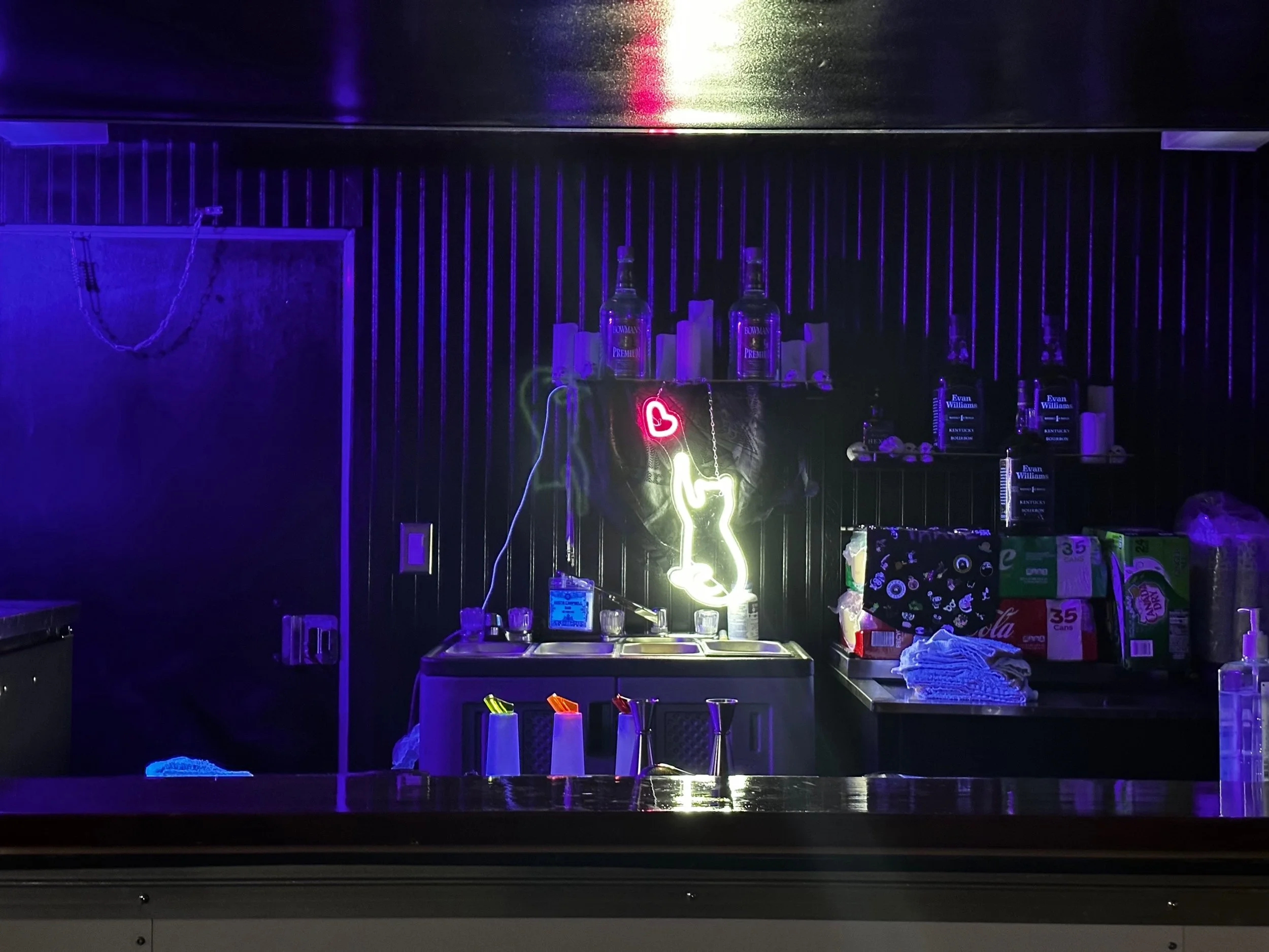 A photo of the interior of Golden Raven Mobile Bar with a neon cat light glowing