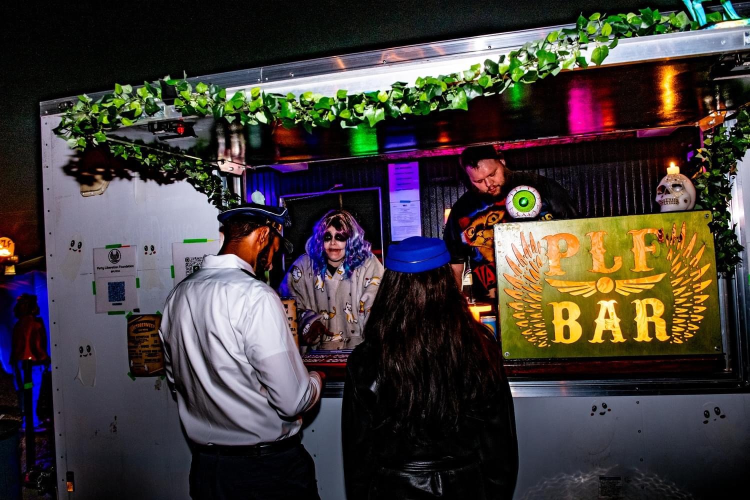 Golden Raven Mobile Bar serving for the non-profit Party Liberation Foundation. Two guests at the window ordering in costume. Photograph by David Morton Photography. 