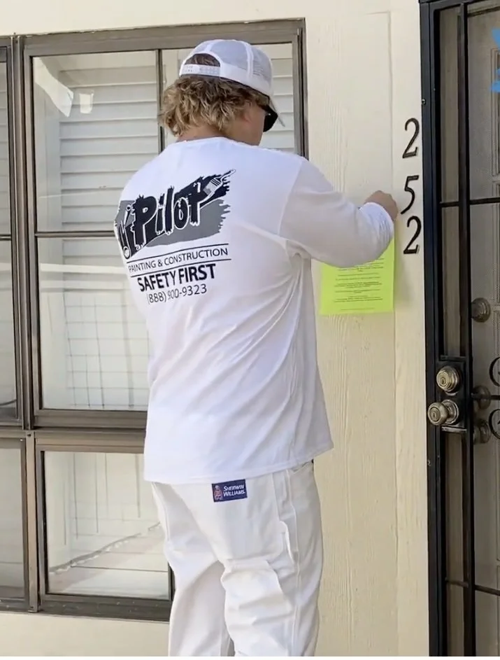 Pilot Crews hanging resident notifications prior to painting an townhome community in Southern California
