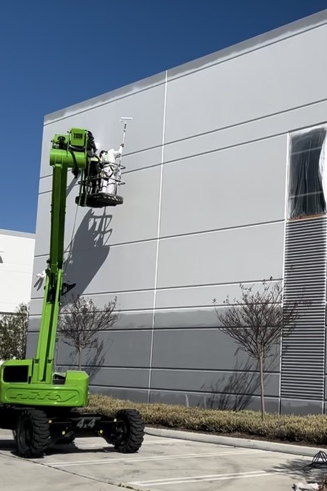 Exterior repaint project for a commercial property with professional painting crew.