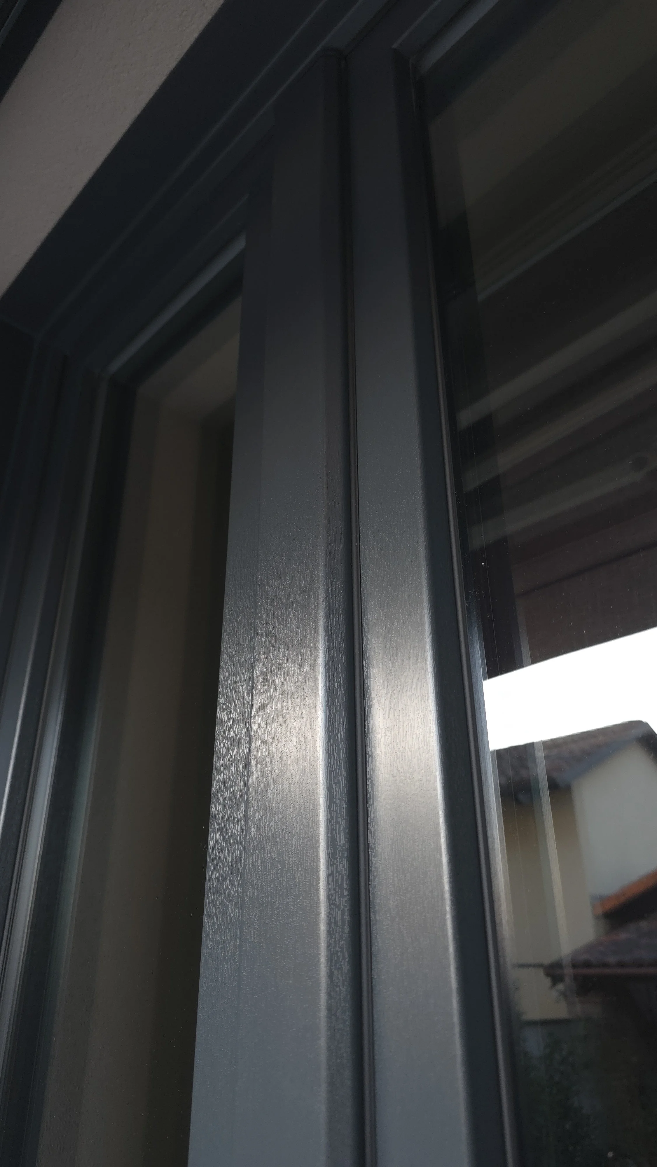 Dettaglio di una finestra con telaio in metallo scuro, visibile da vicino.