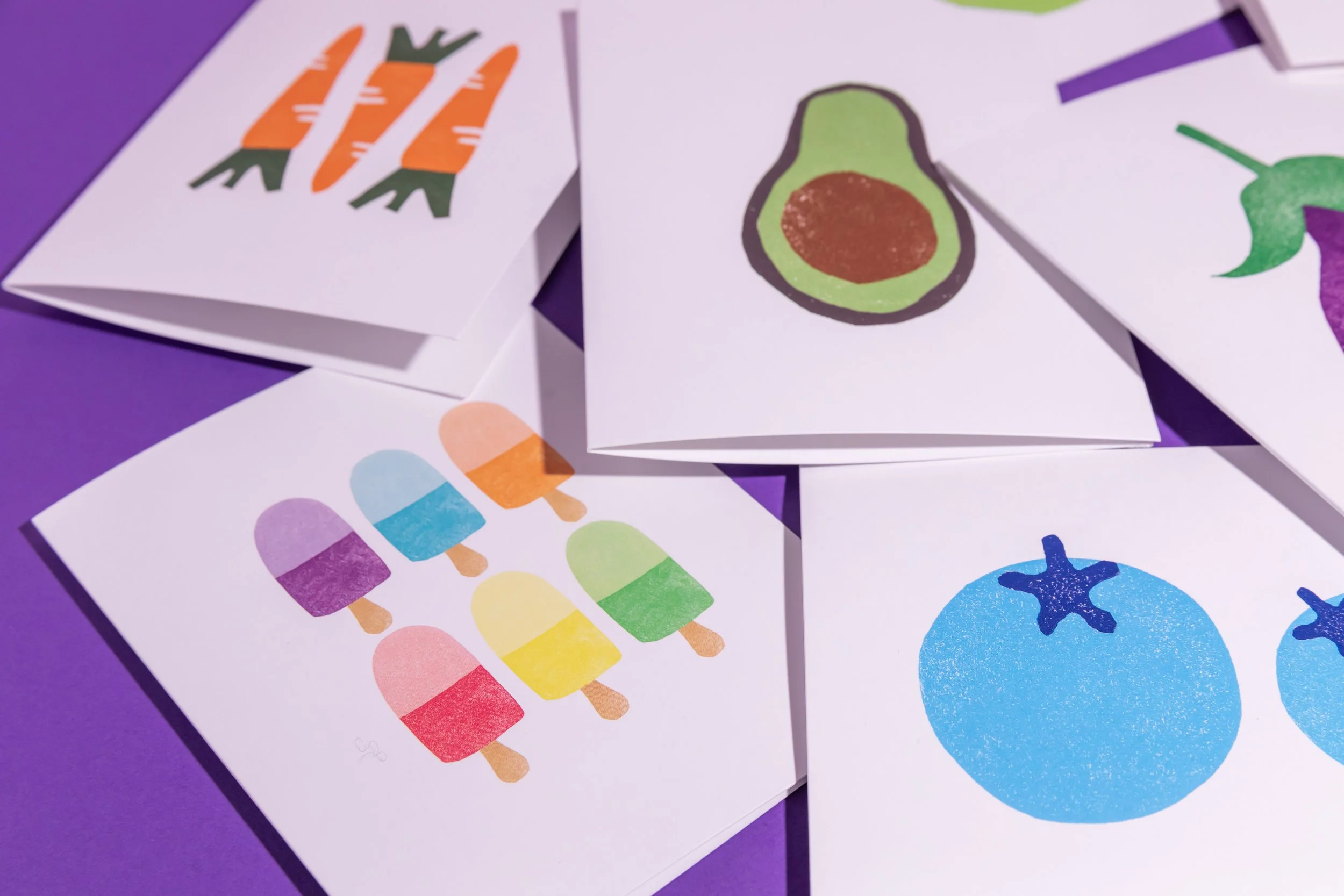 An array of hand-stamped linocut cards featuring produce. Designed by Andrea Morris Studio.