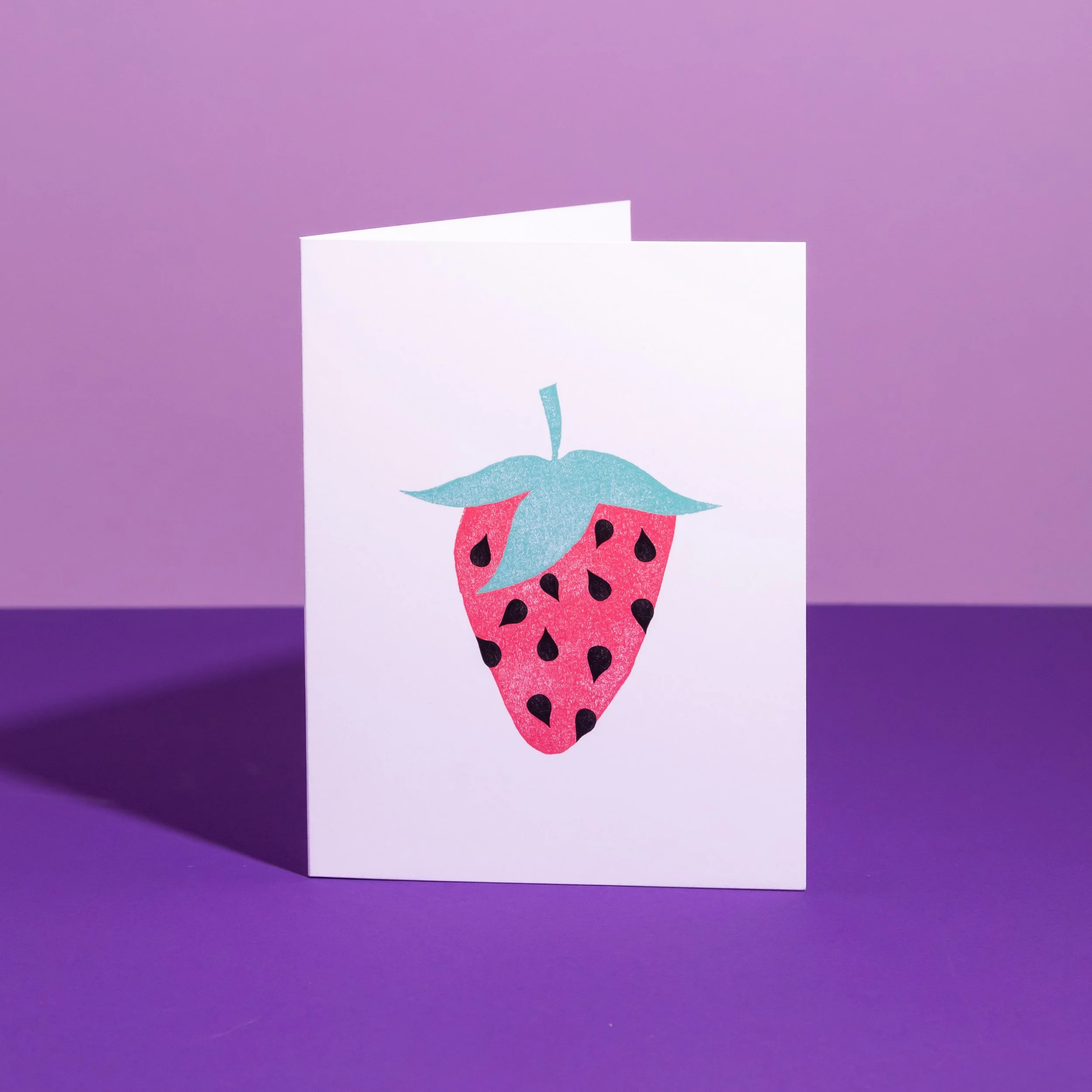 A hand-stamped linocut card featuring a strawberry. Designed by Andrea Morris Studio.