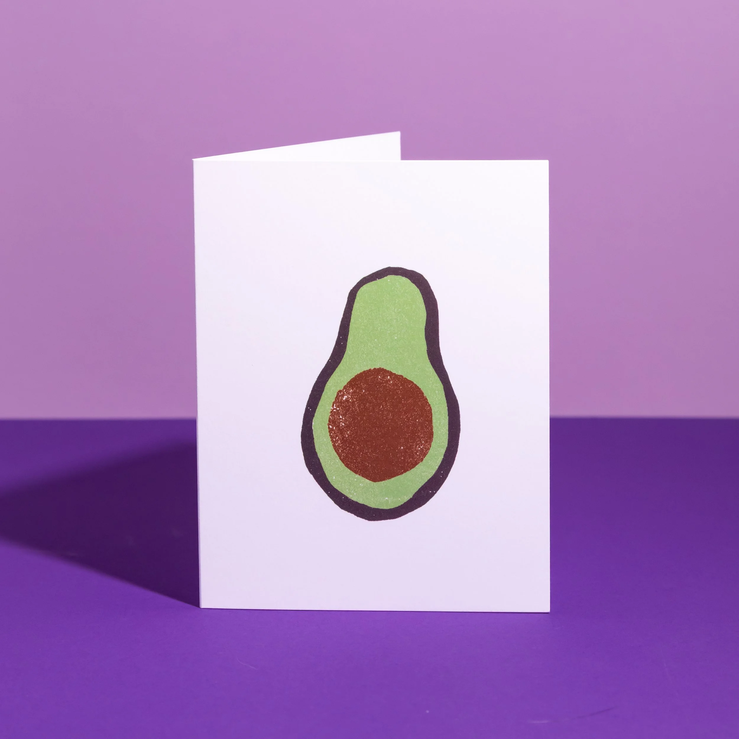 A hand-stamped linocut card featuring avocados. Designed by Andrea Morris Studio.