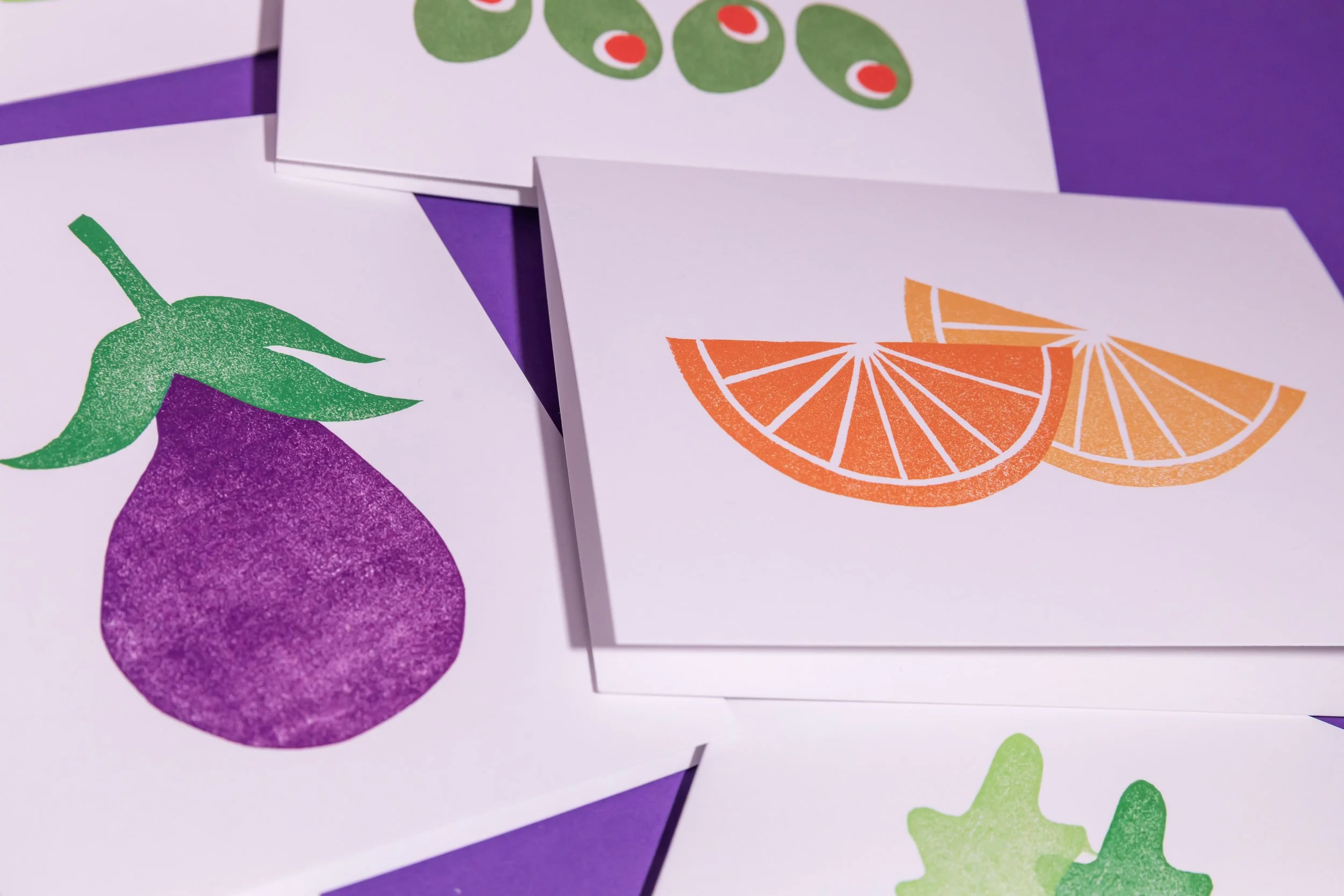 An array of hand-stamped linocut cards featuring produce. Designed by Andrea Morris Studio.