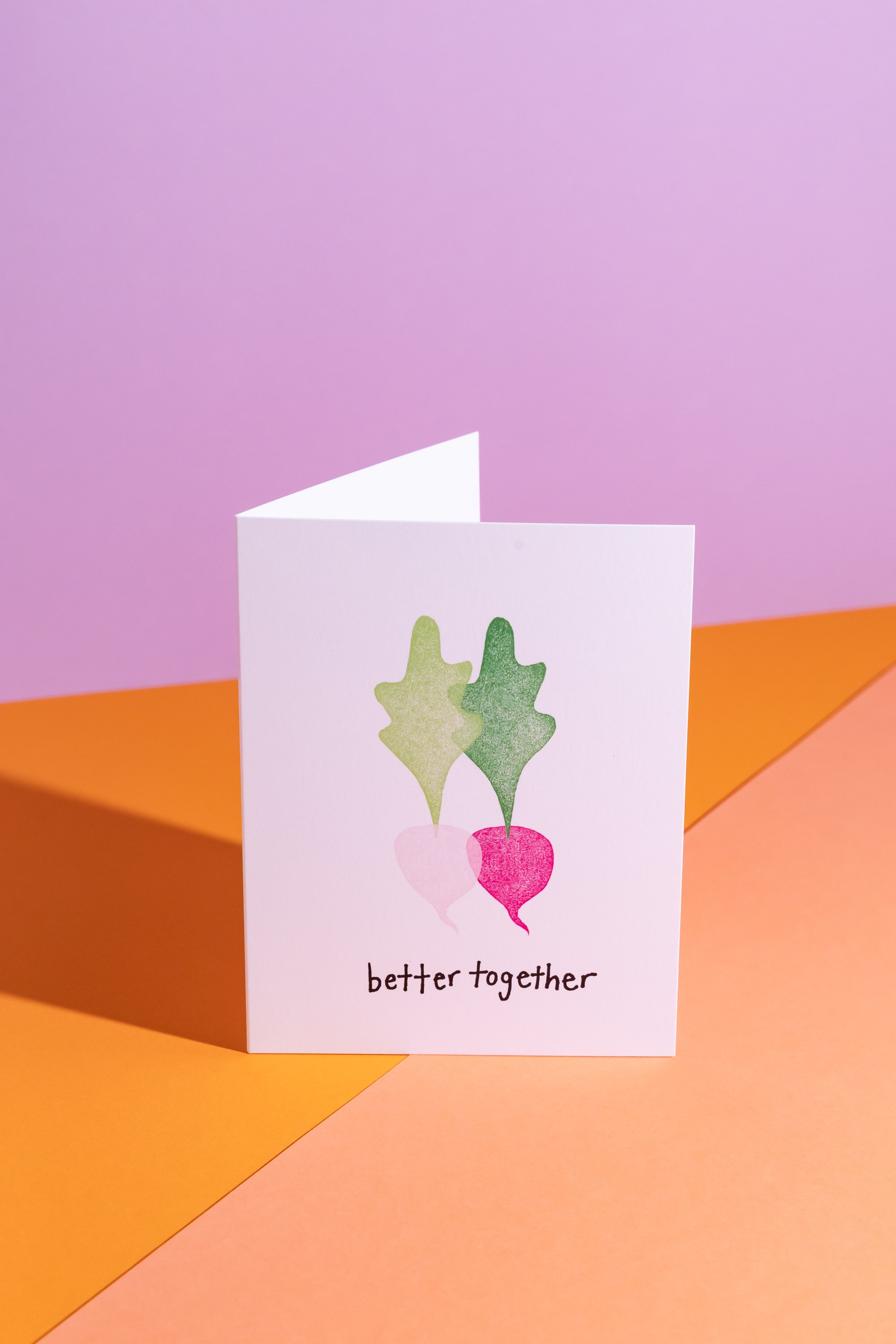 A greeting card featuring two beets with green leaves and pink and white roots, accompanied by the words "better together" at the bottom.