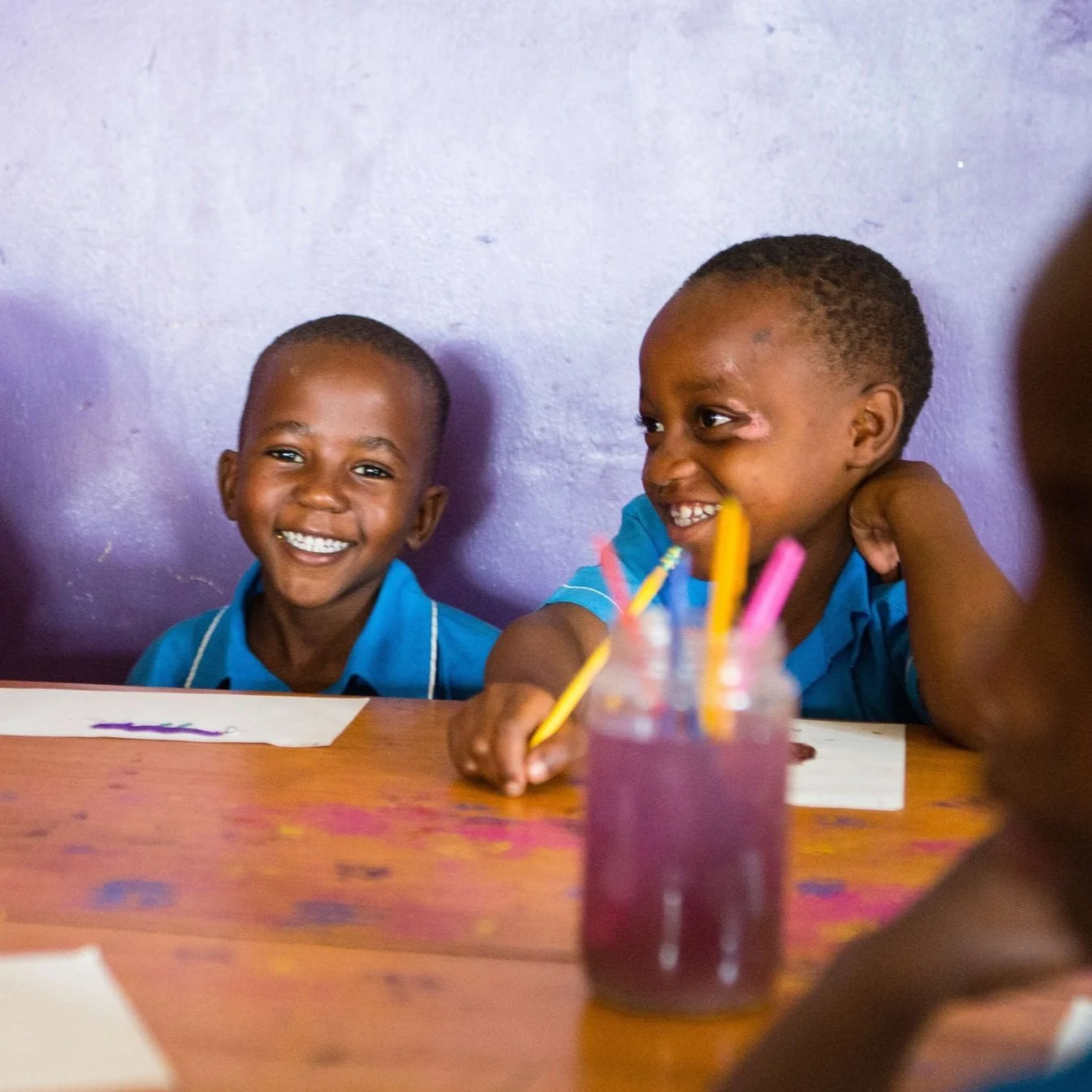 Children smiling in creative arts education.