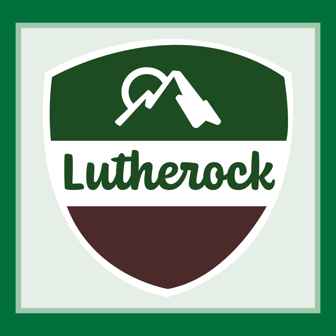 Lutherock's logo. It's in the shape of a scouting badge and features an outline of a mountain with a sun behind it.