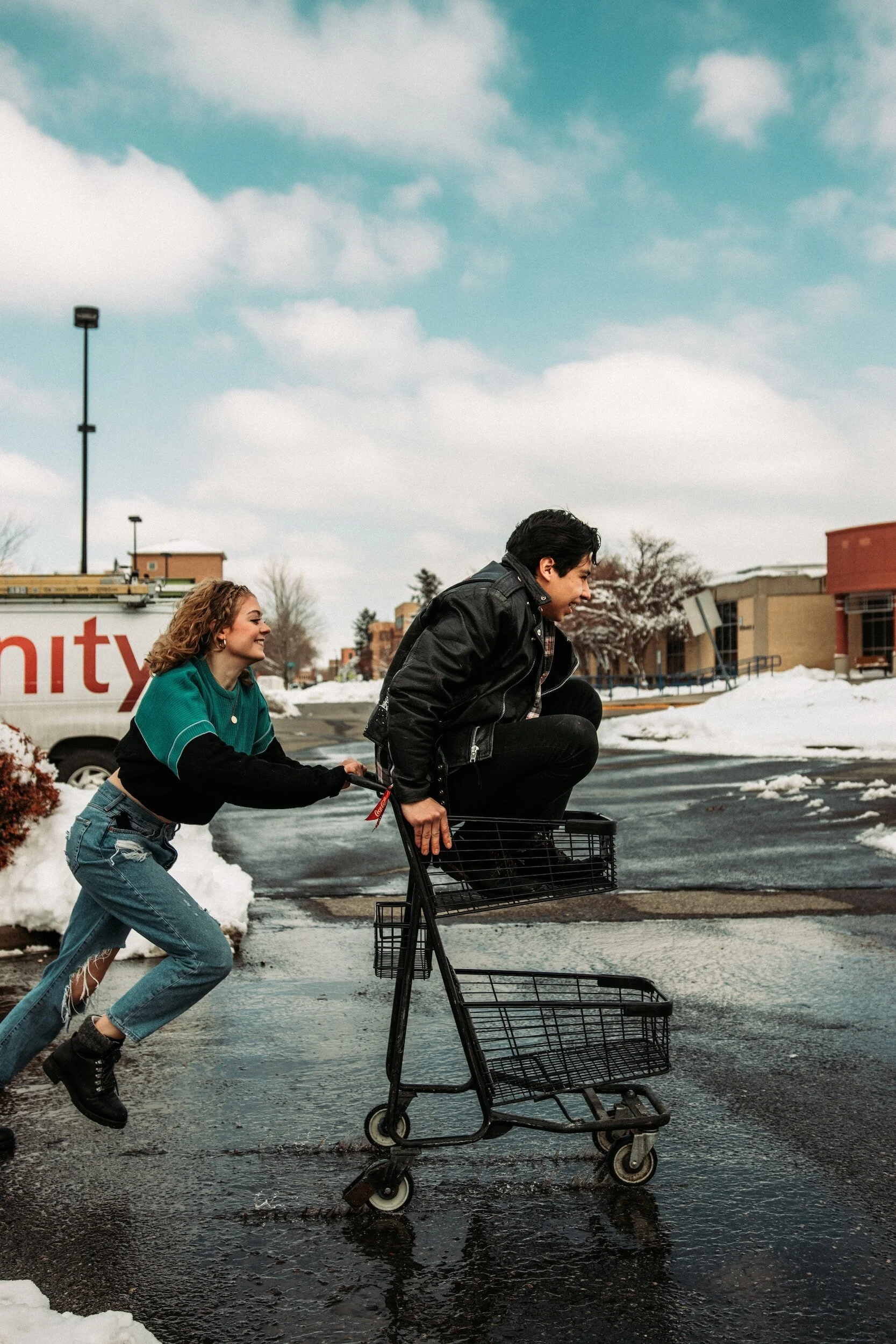 Young adults playing with a shopping cart