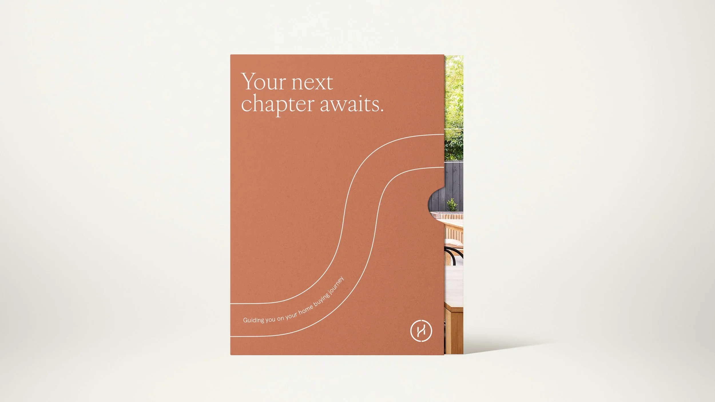 A poster with the message "Your next chapter awaits" and a curved white line design, with a partial view of a porch with outdoor furniture and greenery visible to the right.