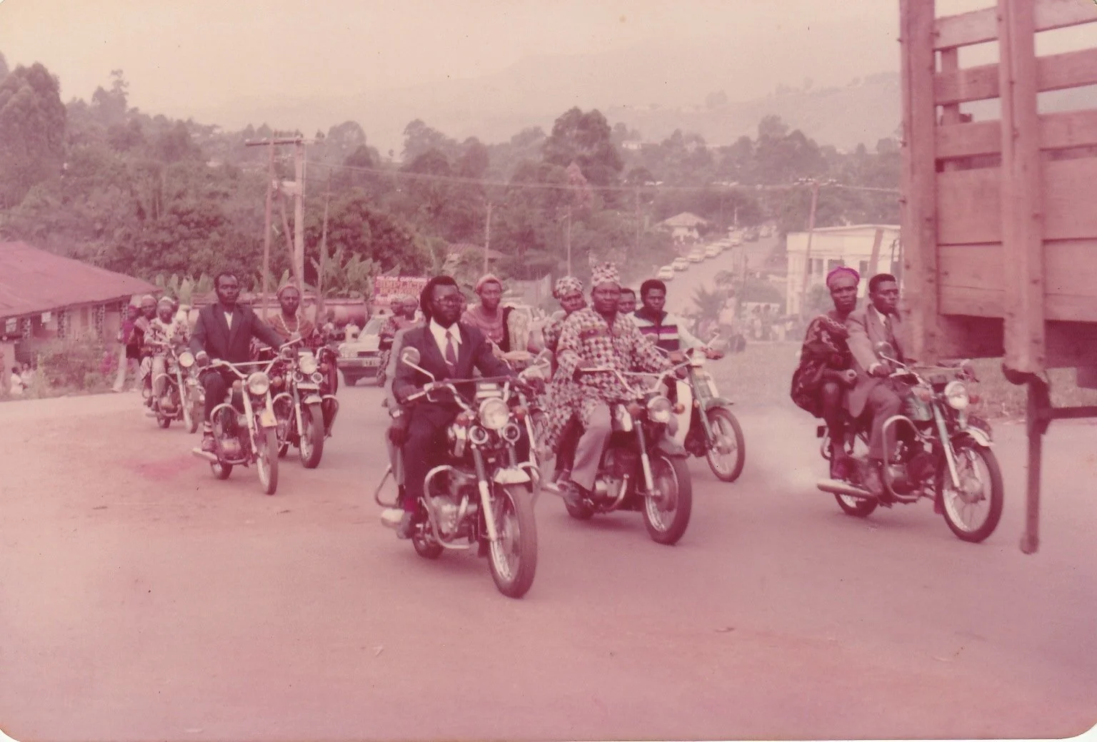 Daisy's father's classmates form a motorcade following her parents' wedding ceremony to the reception (Cameroon, 1980s)