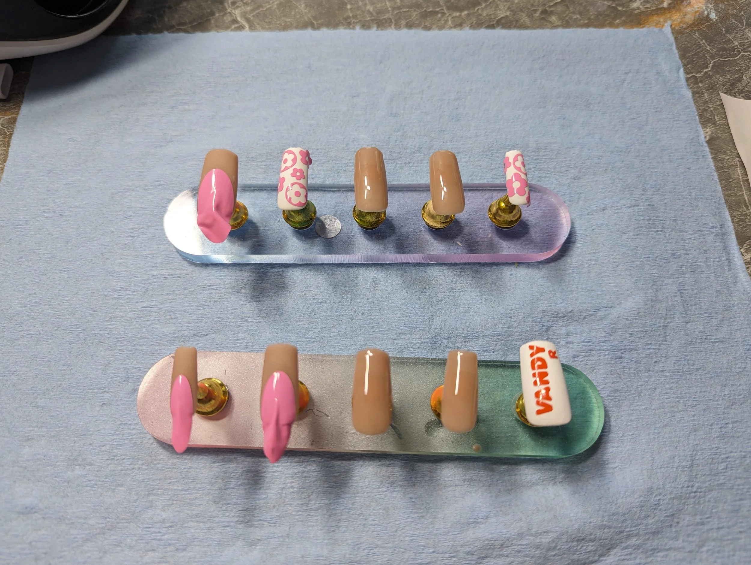 A progress photo of the nail set while they are prepped with custom stencils